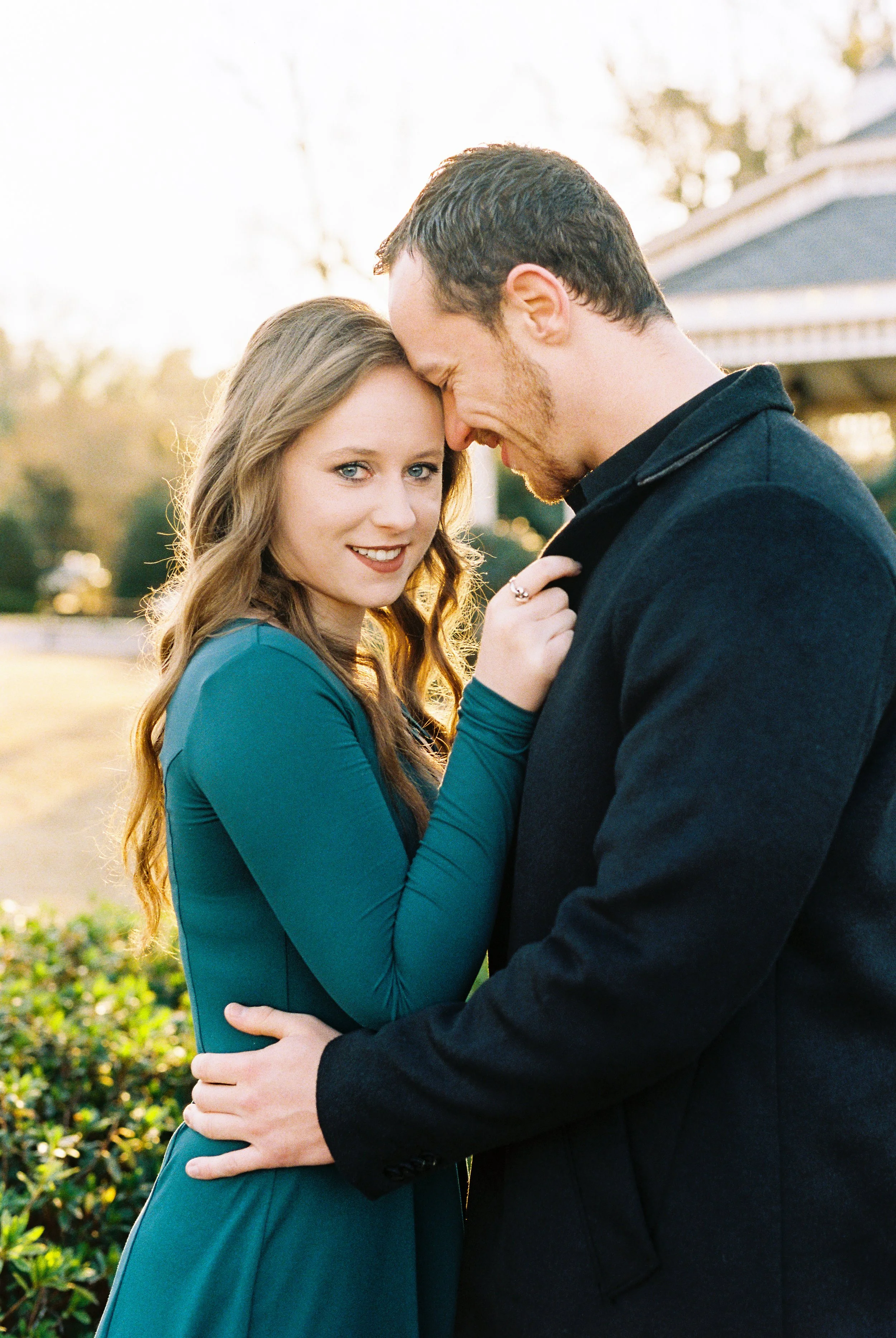 Maddie glances at the camera while embracing Conner forehead to forehead in golden hour light in Dallas, Georgia.