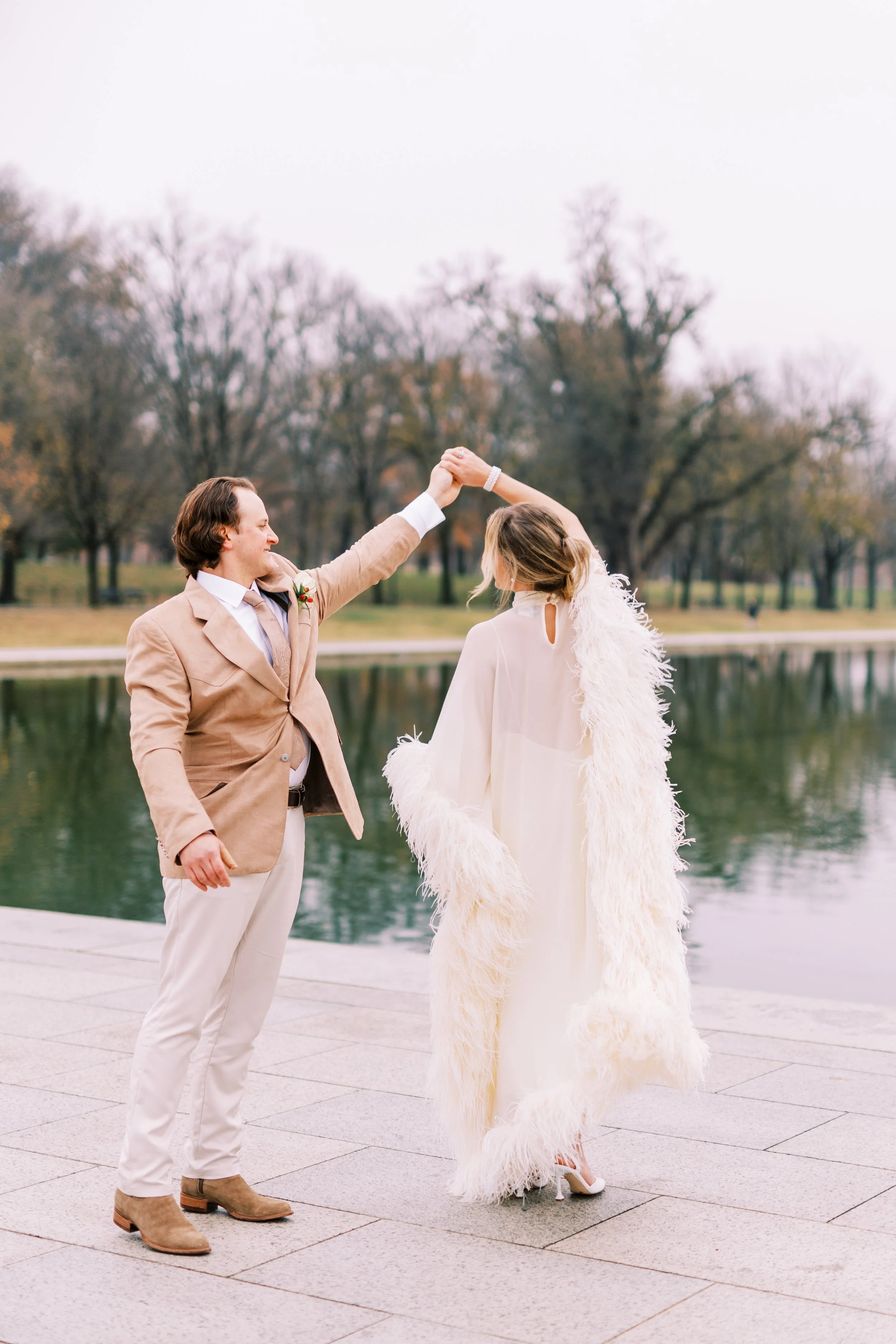 Groom twirling the bride in a joyful dance by the waterfront