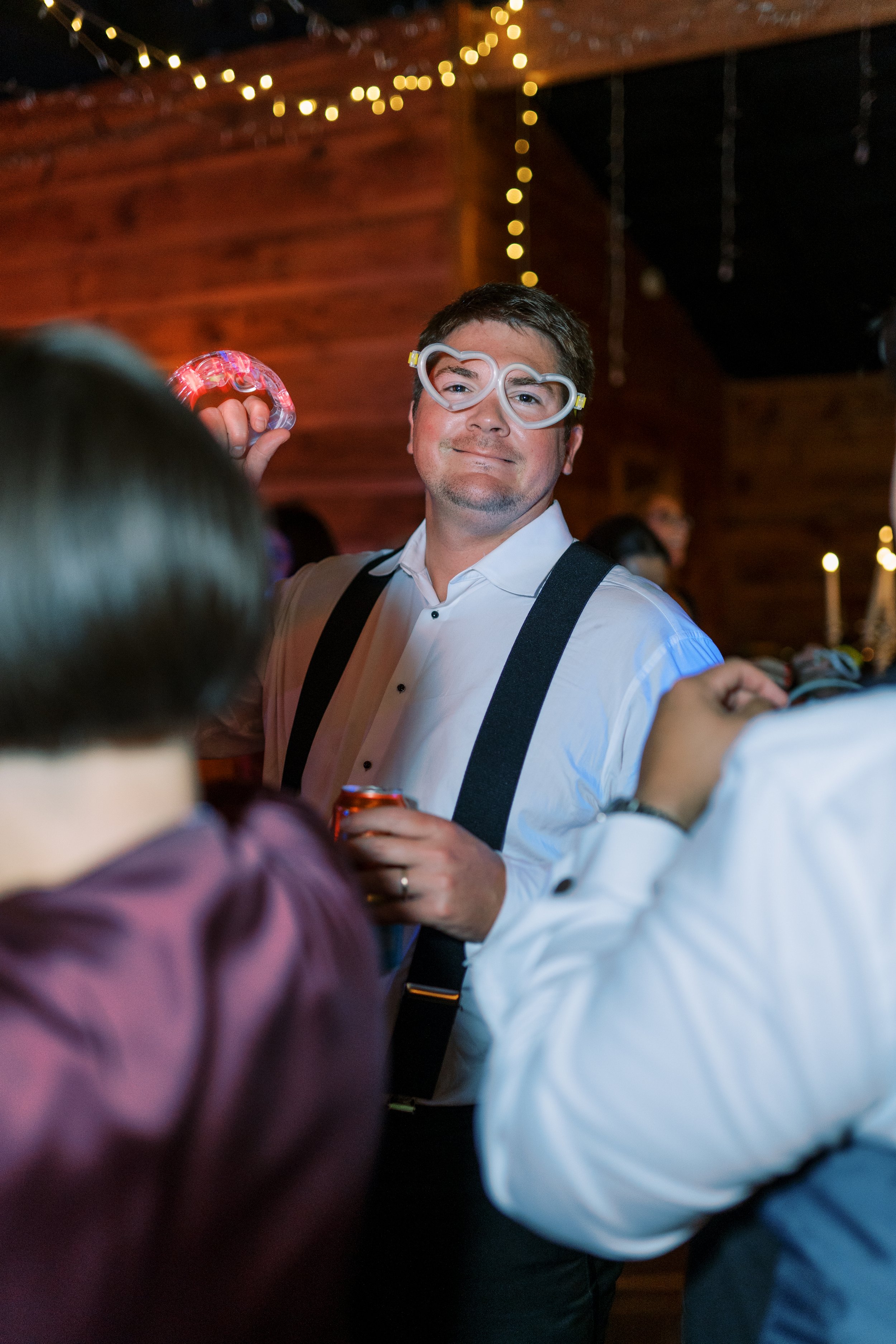 Guest dancing playfully in sunglasses at the reception