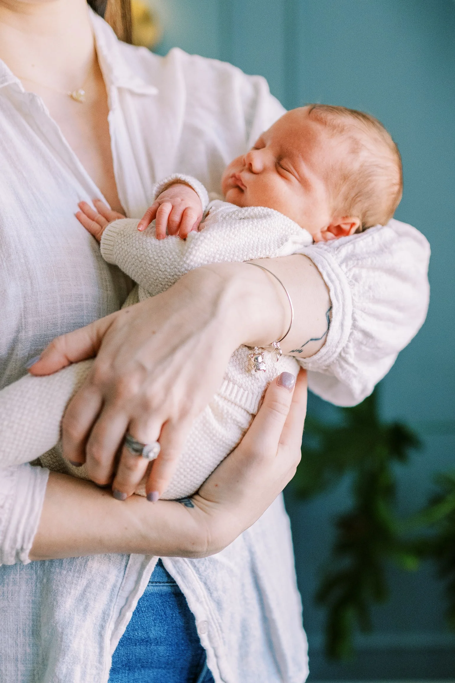 Mother smiling brightly at the camera while holding her newborn baby in the nursery, Roswell, Georgia