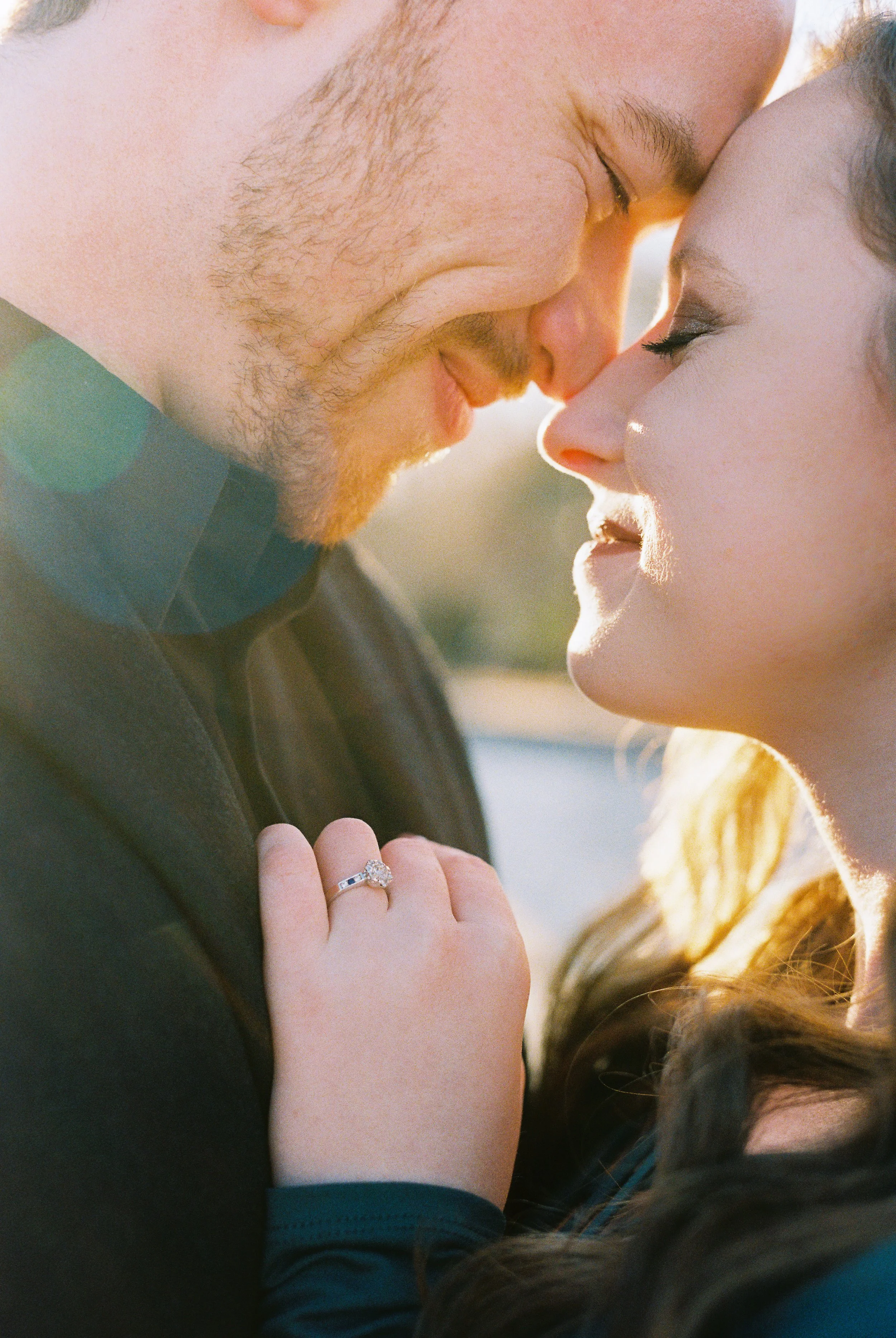 A close-up of Conner and Maddie nose to nose, her engagement ring visible on her hand, bathed in golden hour light in Dallas, Georgia.