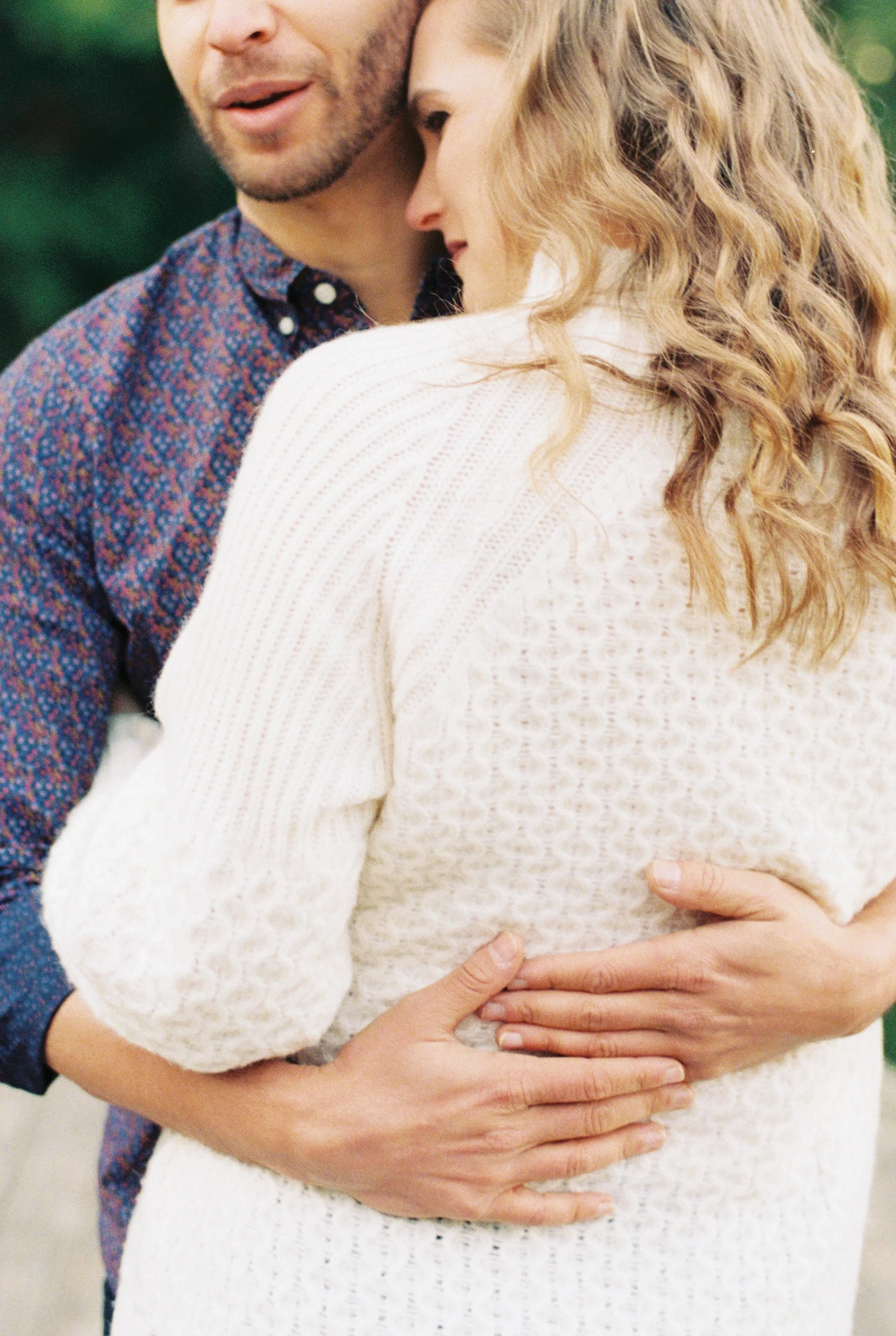Close embrace between the engaged couple, foreheads together with hands clasped