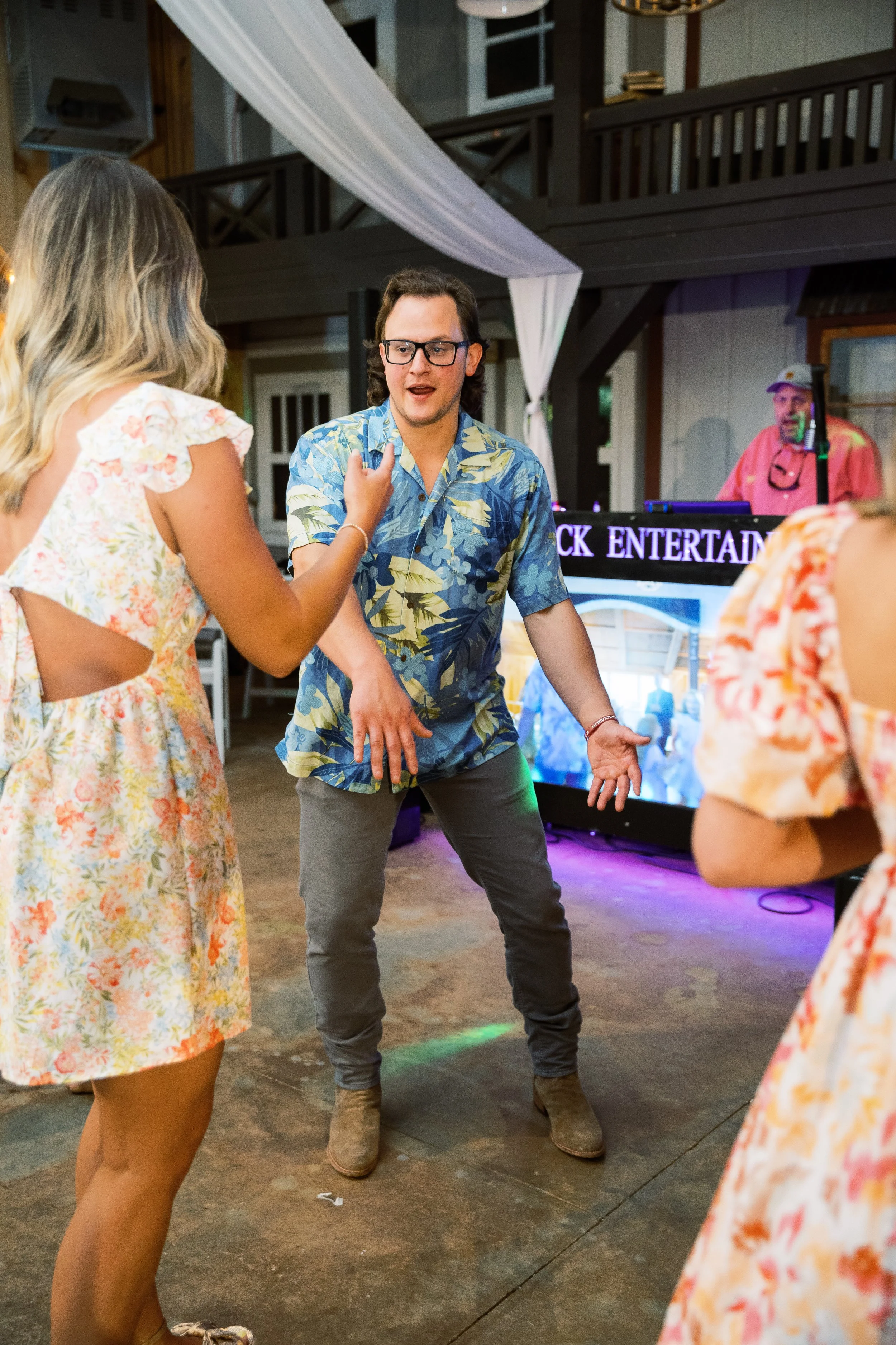 Guests dancing energetically on the dance floor under colorful party lights