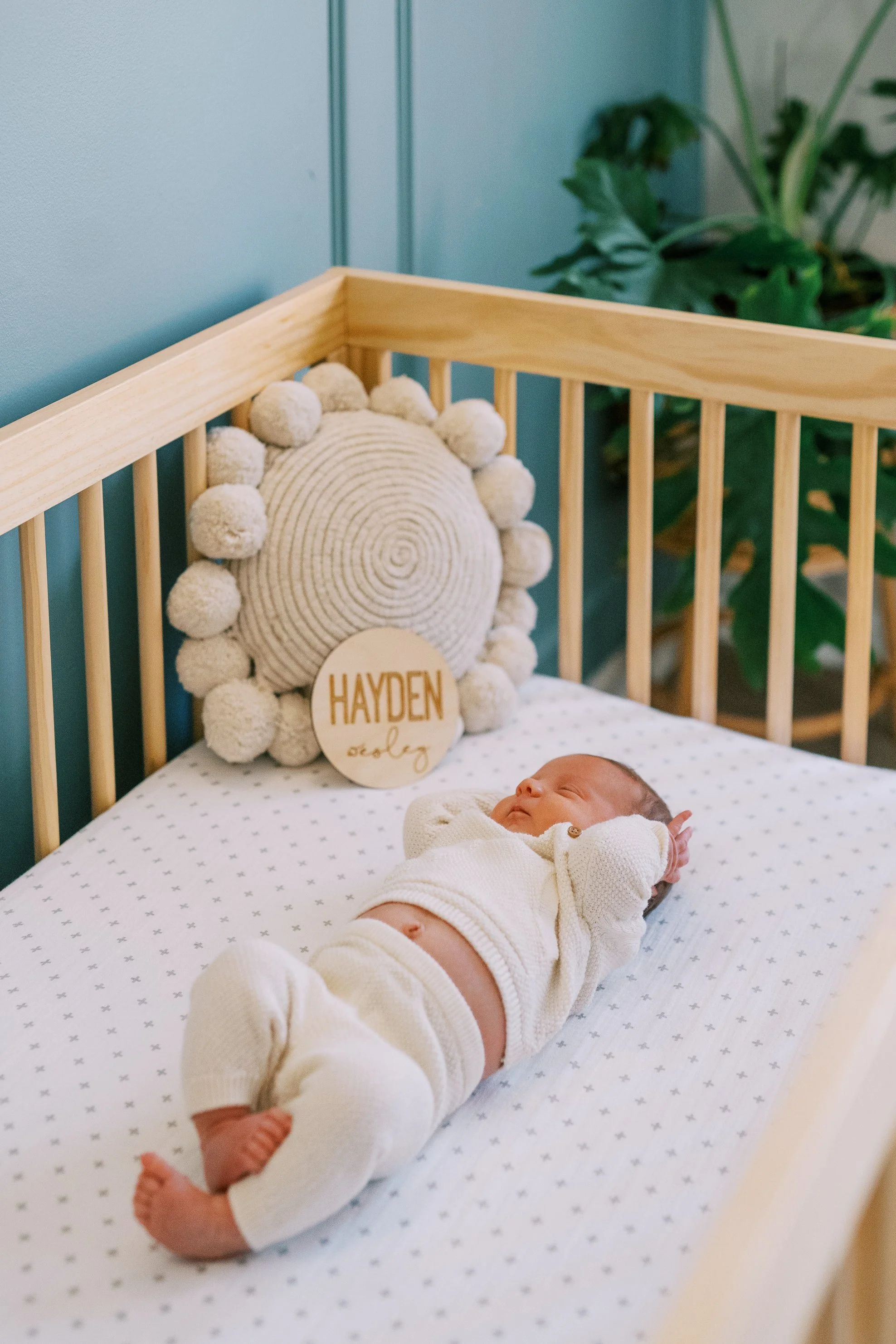 Newborn baby sleeping peacefully in the crib, viewed through the wooden slats, Roswell, Georgia