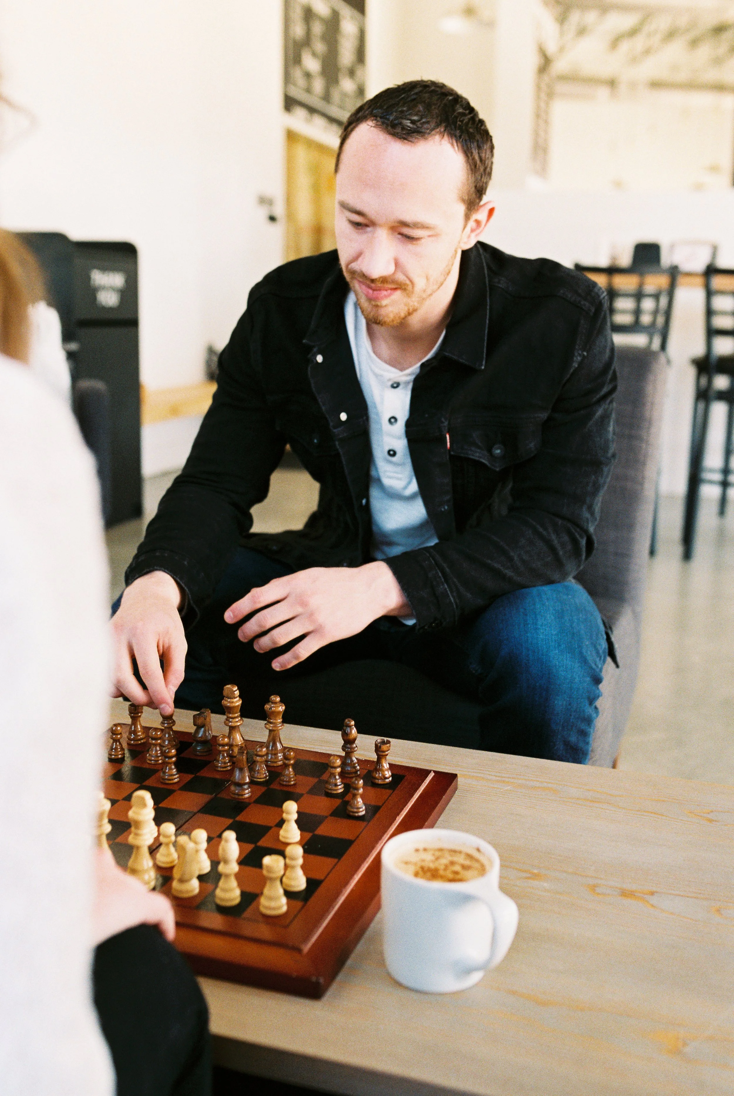 Conner considers his next chess move across the table from Maddie in a Dallas, Georgia coffee shop.