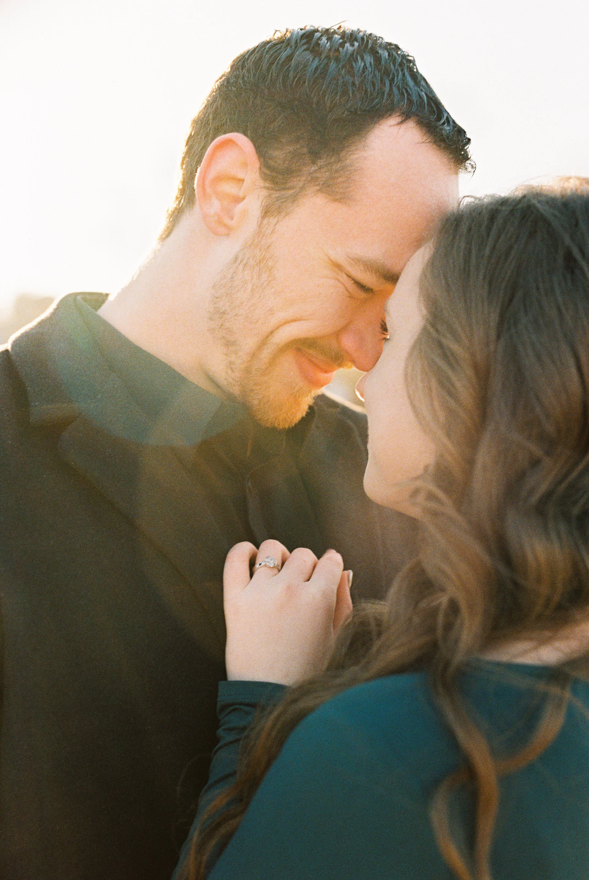 Conner grins as he leans his forehead toward Maddie, backlit by soft sunlight in Dallas, Georgia.