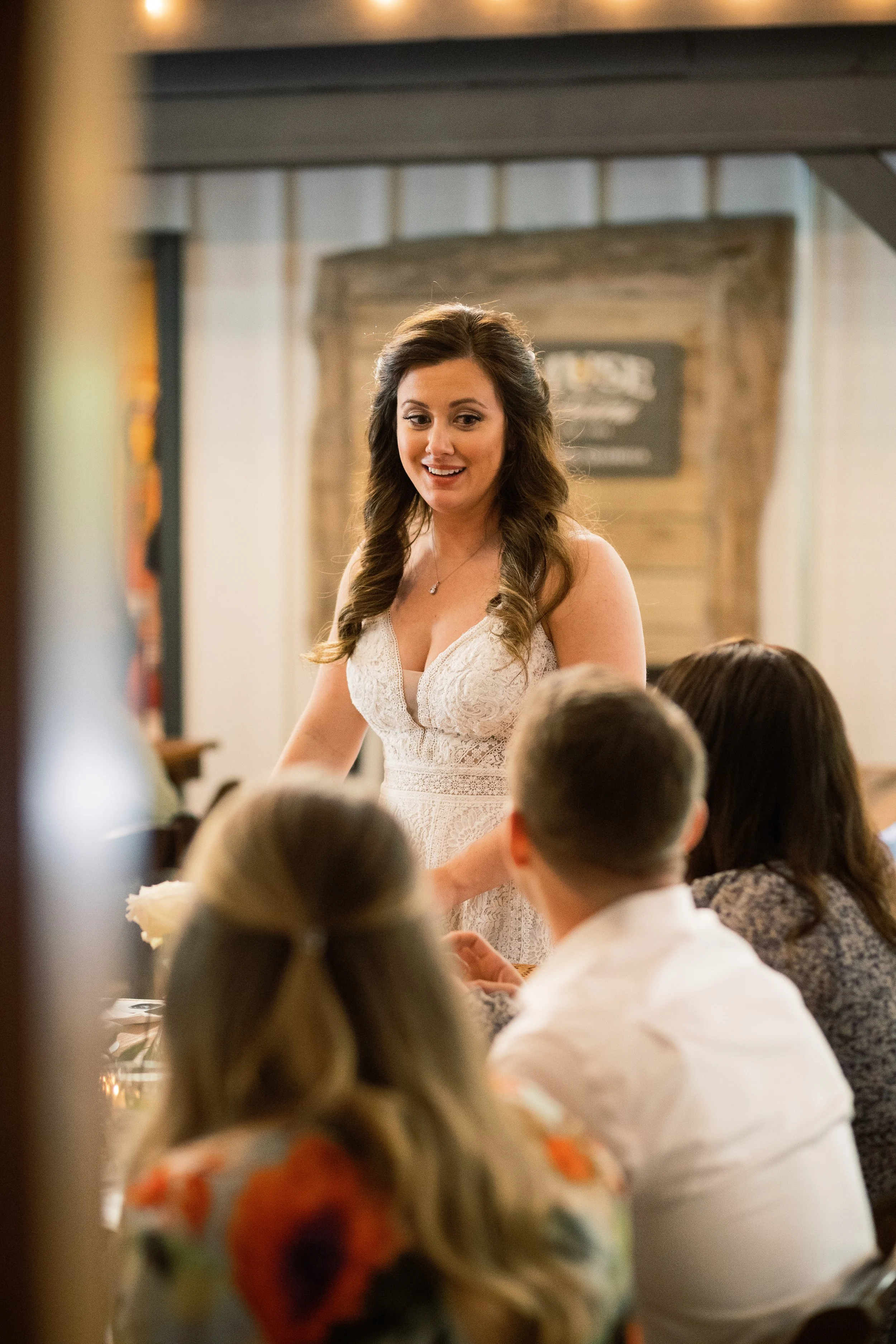 Bride giving a toast to seated guests during the reception