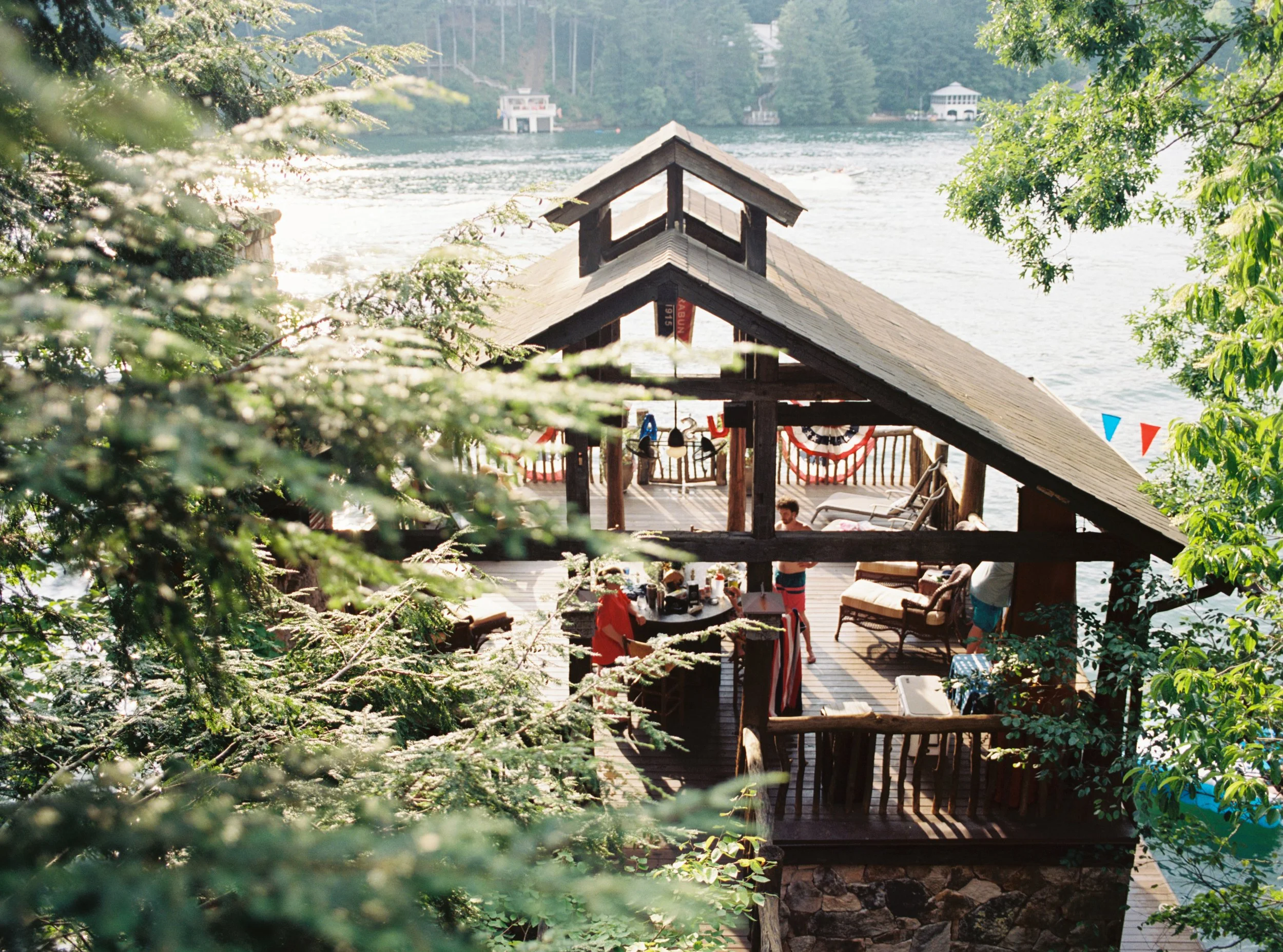 Rustic wooden boathouse and pavilion at Lake Rabun, Georgia, framed by pine trees with lake view