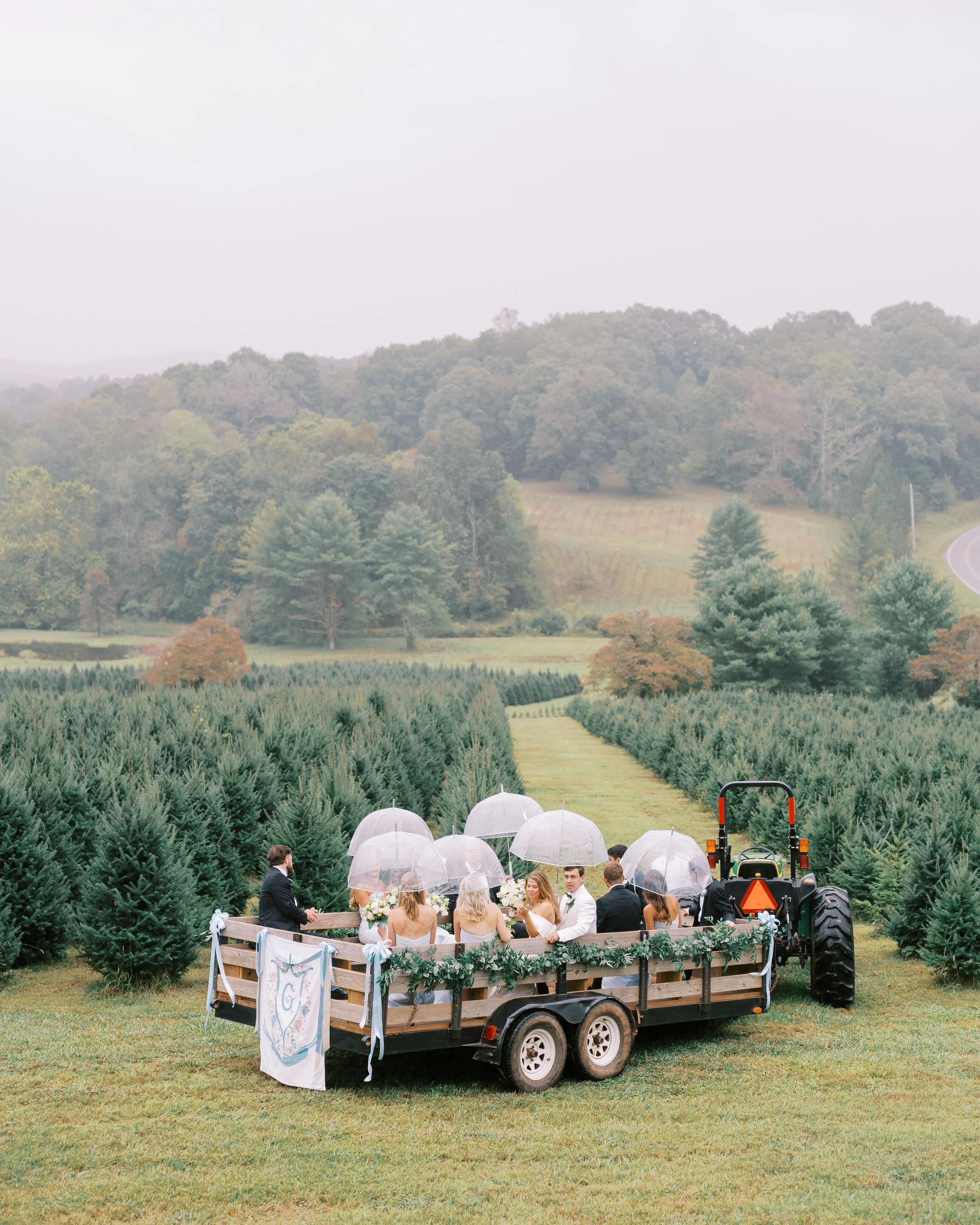 Wide landscape view of the wedding party wagon ride through the fields