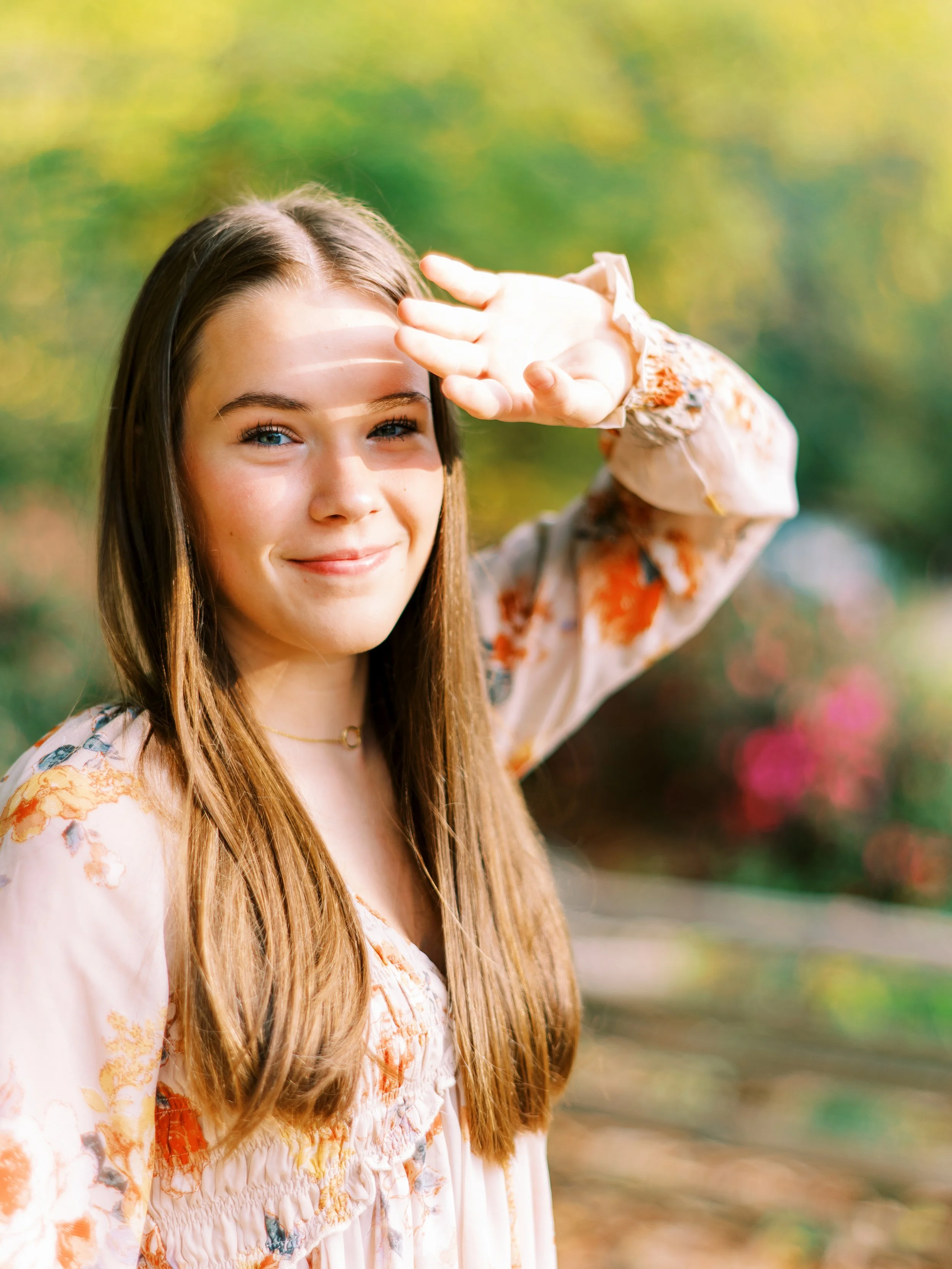 Close-up senior portrait of Hannah smiling in a floral dress at Kennesaw Mountain Battlefield Park in Kennesaw, Georgia