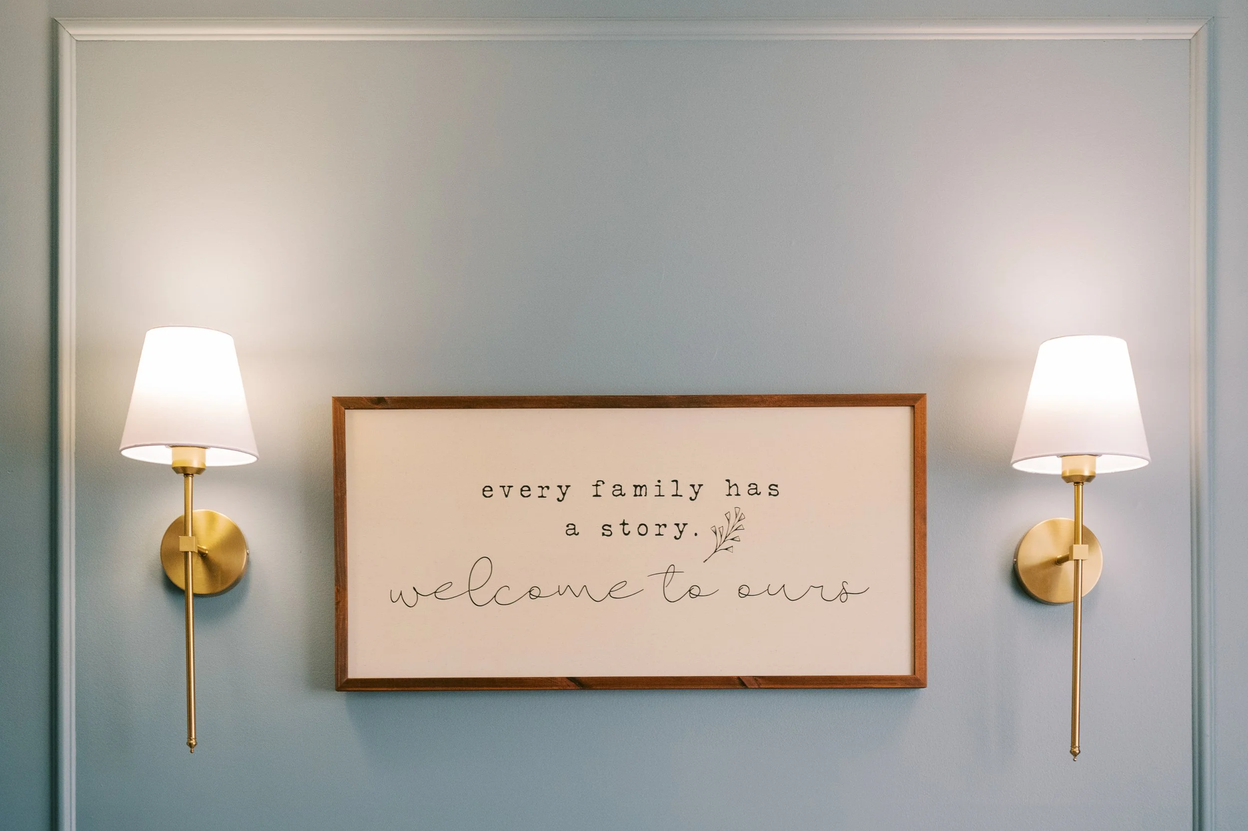 Framed nursery sign reading 'every family has a story, welcome to ours' in Roswell, Georgia home