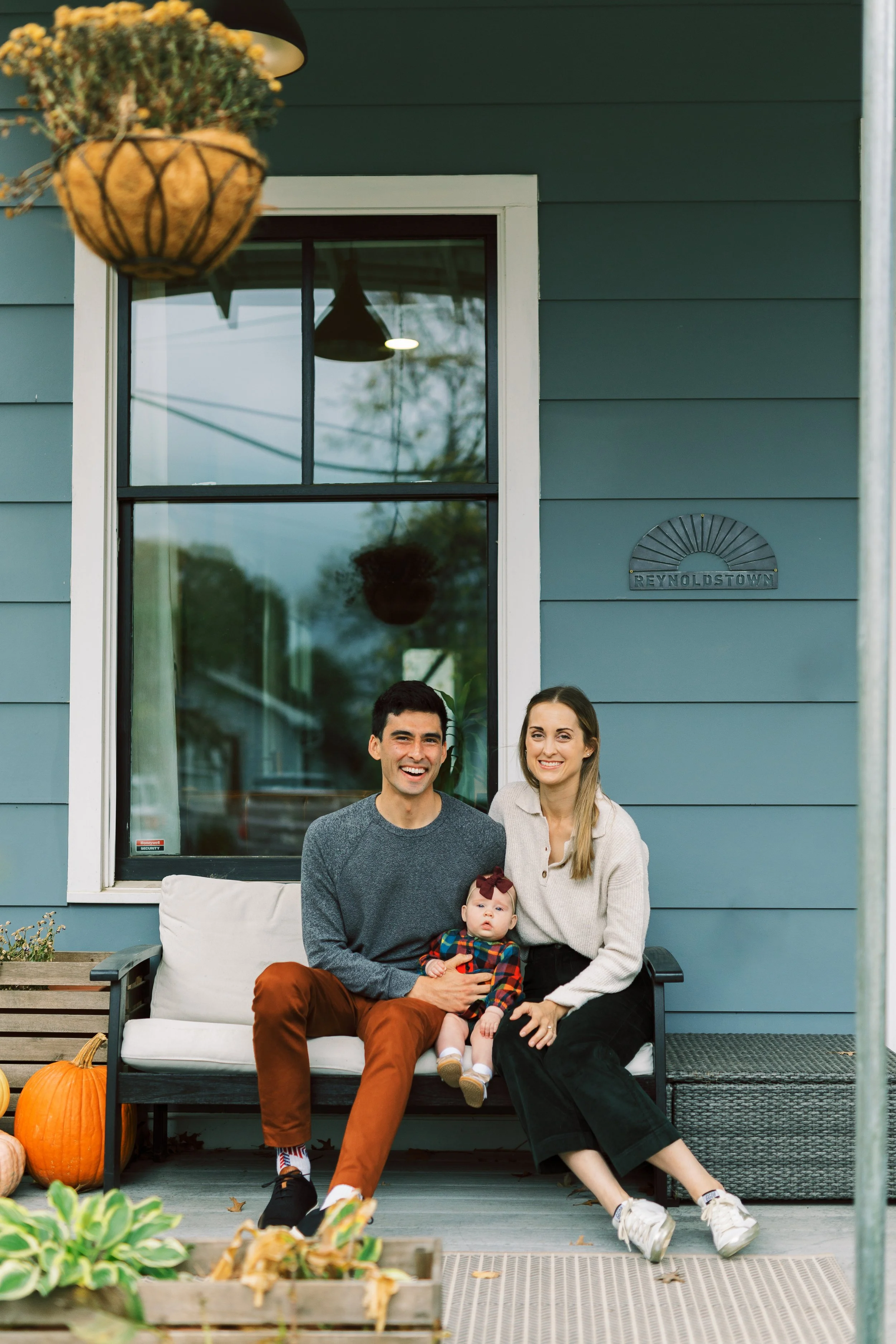 Parents sitting on the porch swing with their baby daughter, Reynoldstown, Atlanta, Georgia