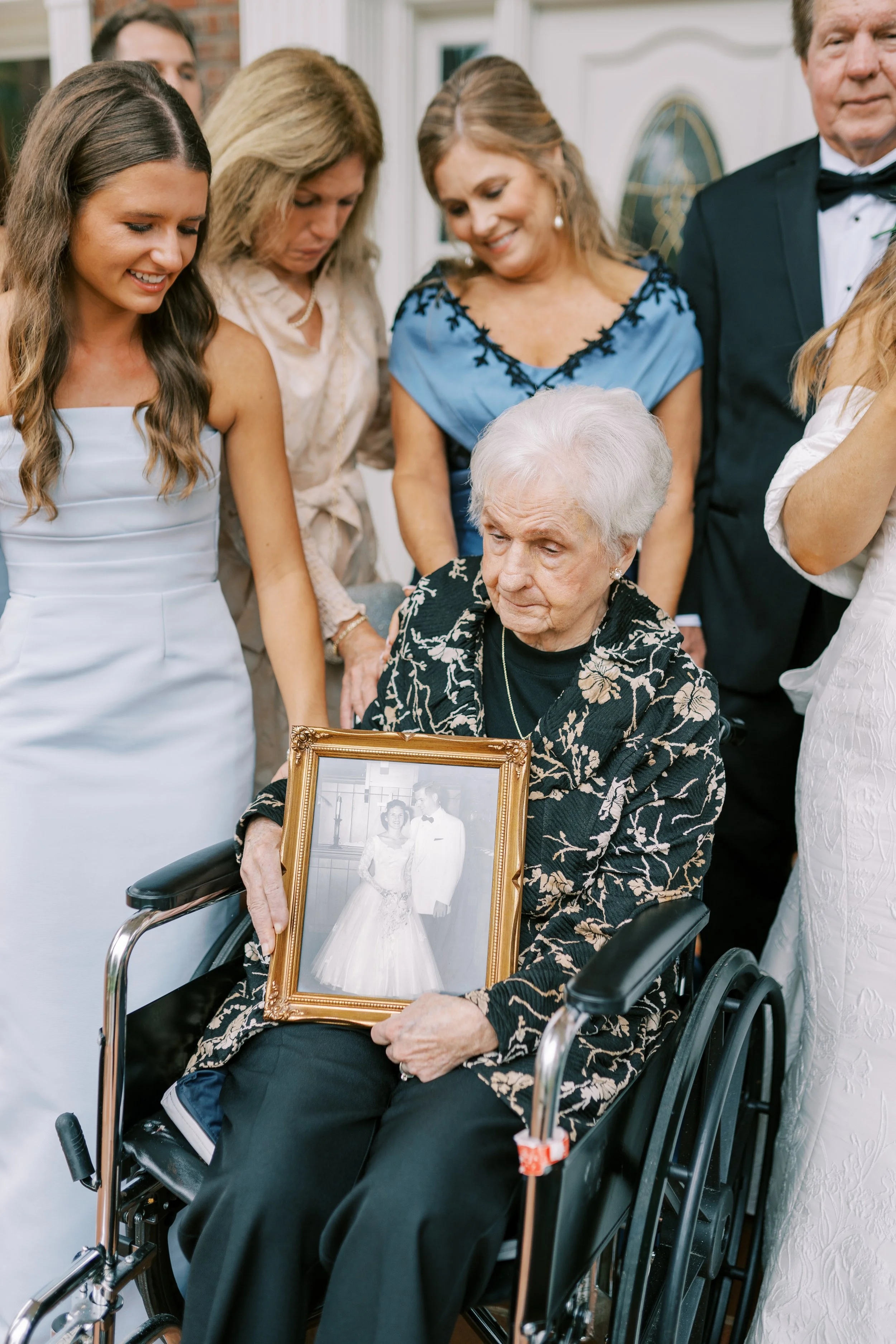 Bride's family gathered around her grandmother holding a cherished photo
