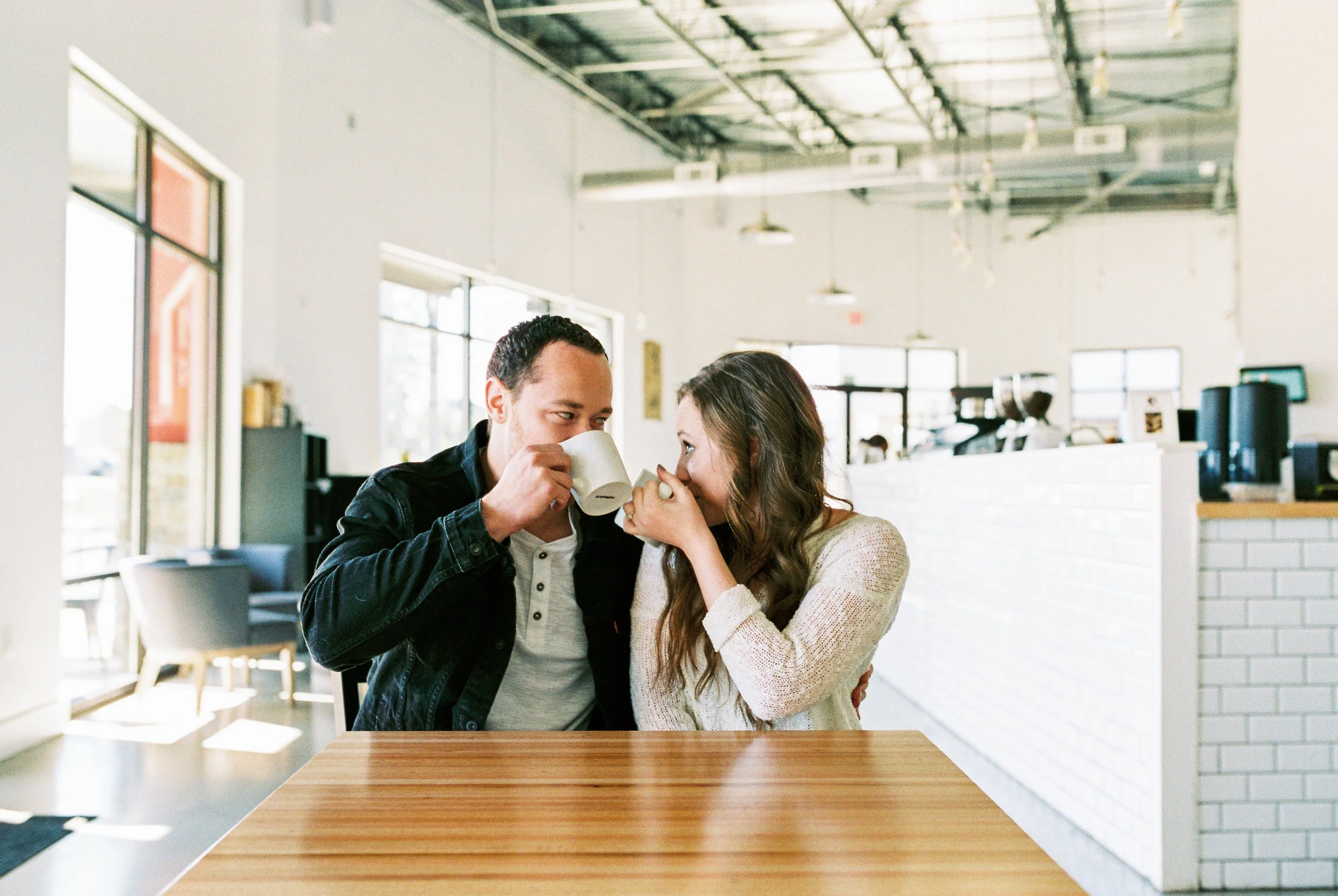 Conner and Maddie sip their coffee together at a table in a Dallas, Georgia coffee shop.
