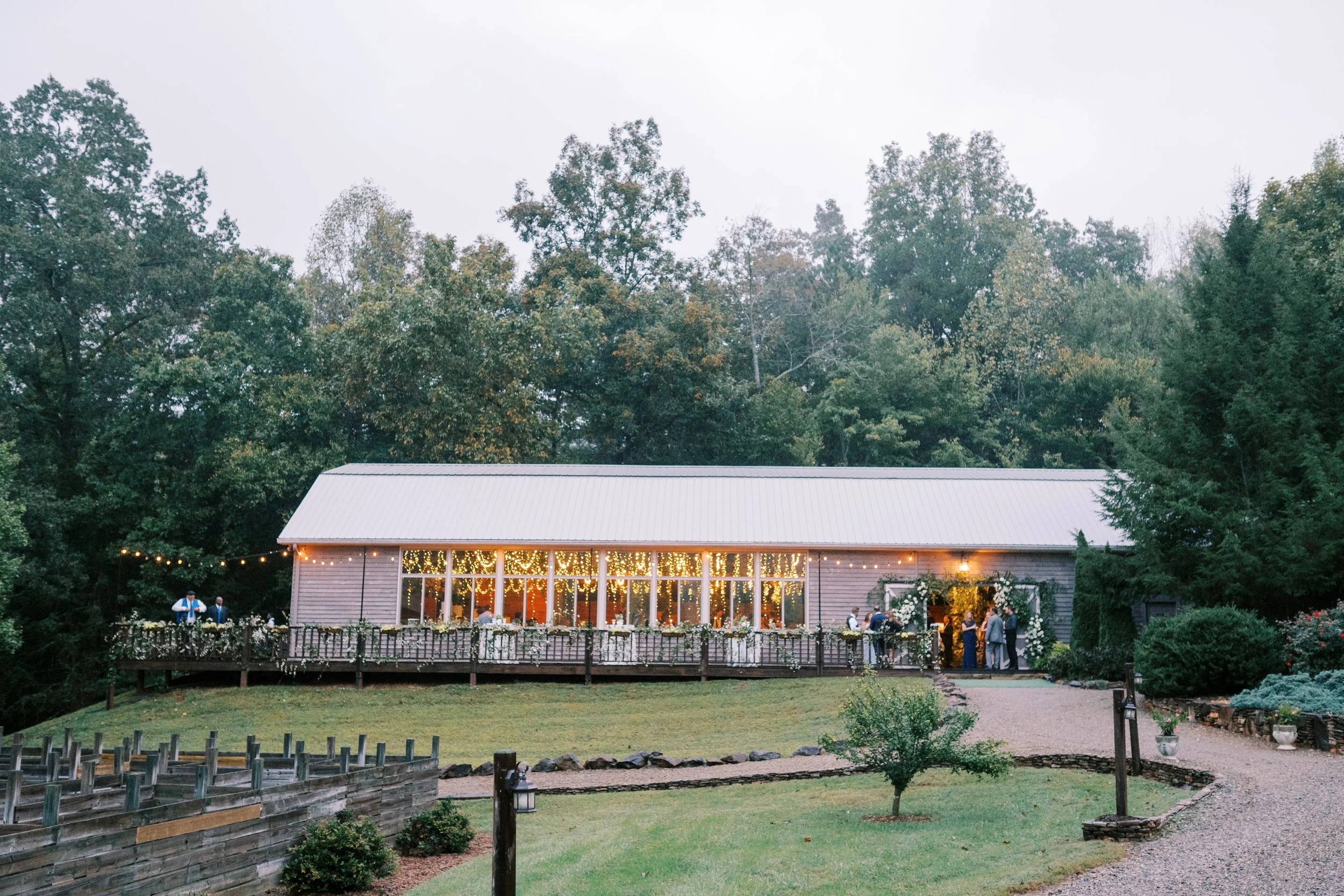 Reception venue exterior glowing with lights at dusk