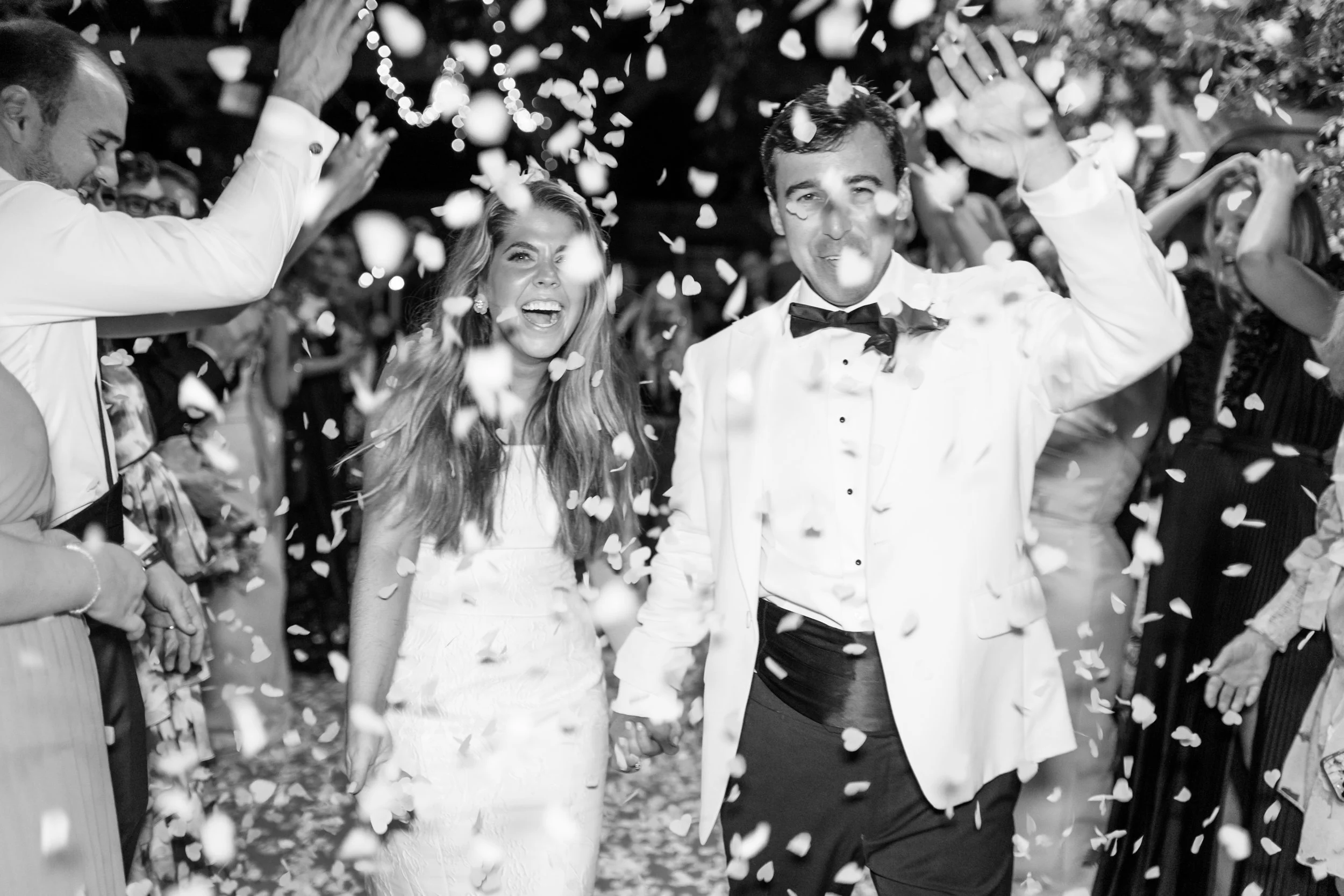 Black and white photo of bride and groom celebrating their confetti sendoff