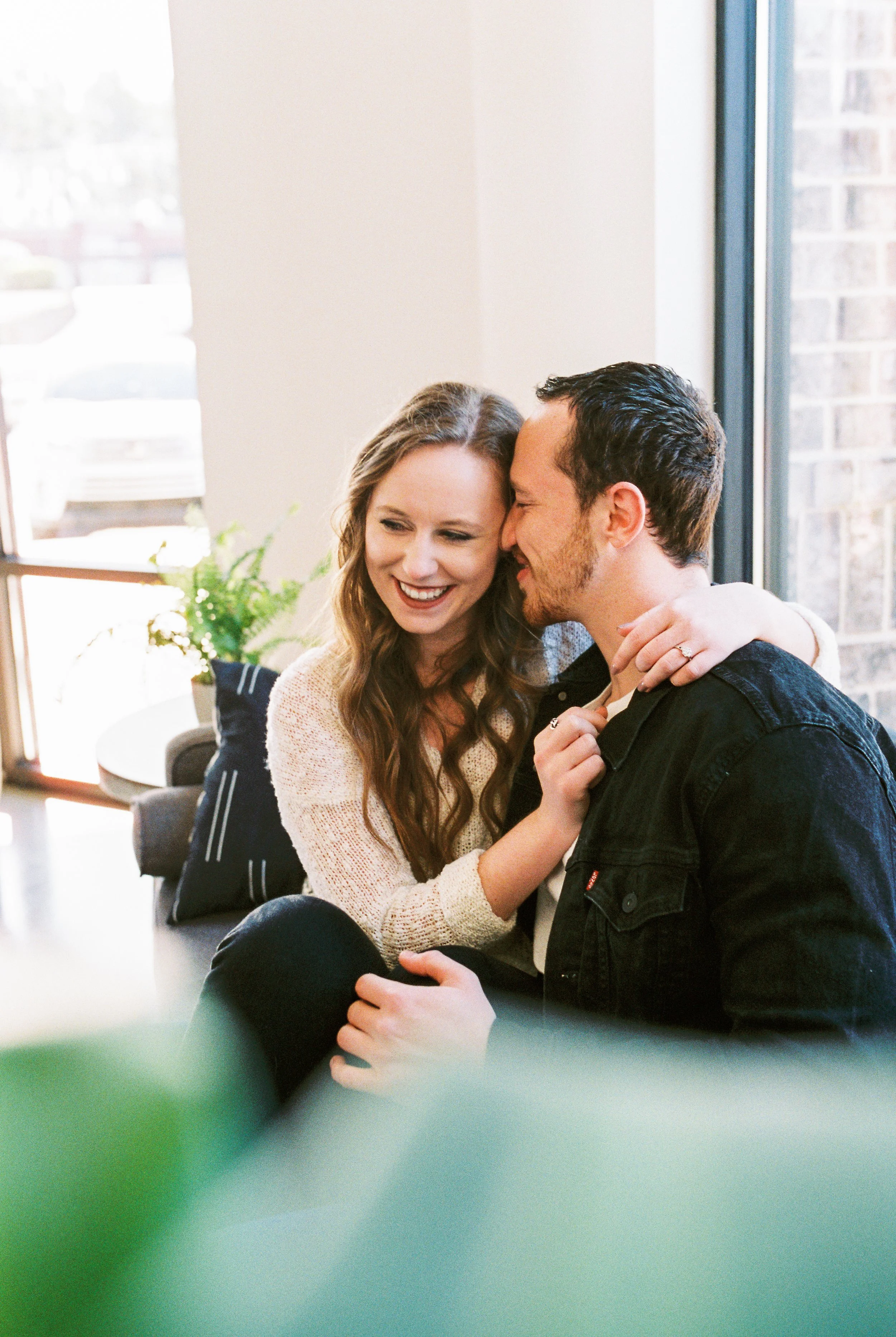 Conner nuzzles Maddie's cheek as she rests her hand on his shoulder on a couch in a Dallas, Georgia coffee shop.