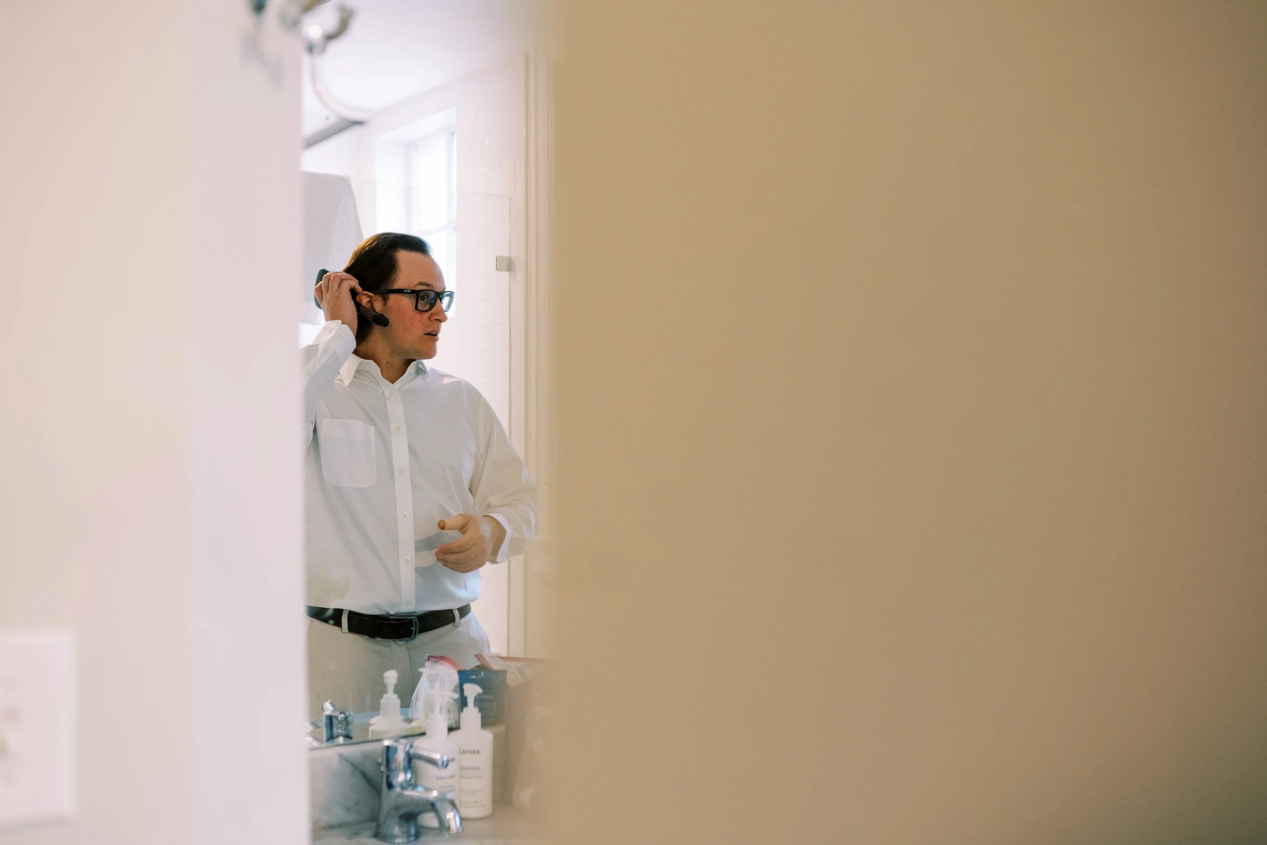 Groom getting ready in a doorway before the Washington DC elopement ceremony