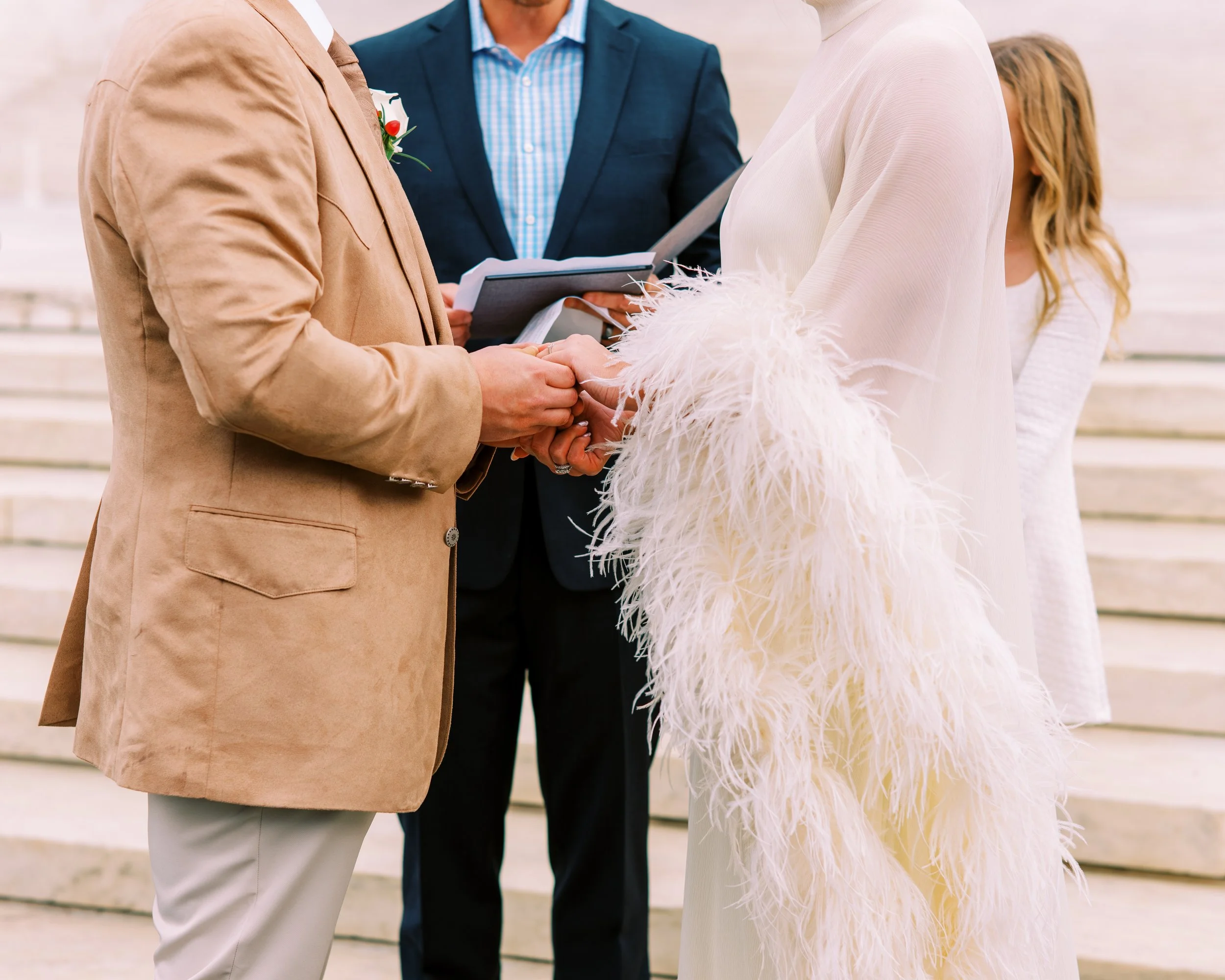 Officiant leading the bride and groom through their wedding vows while holding hands