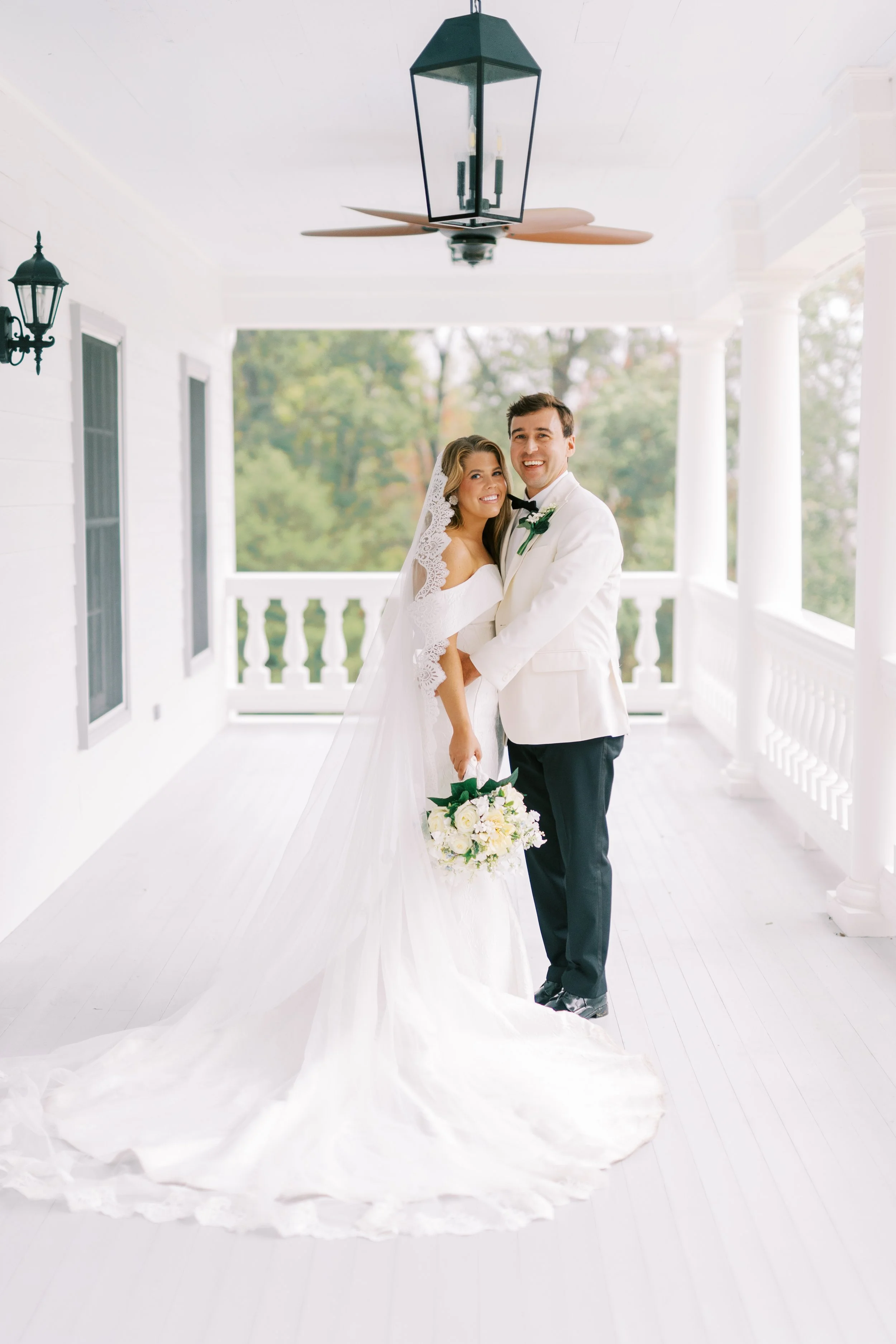 Groom lifting the bride playfully in the covered breezeway