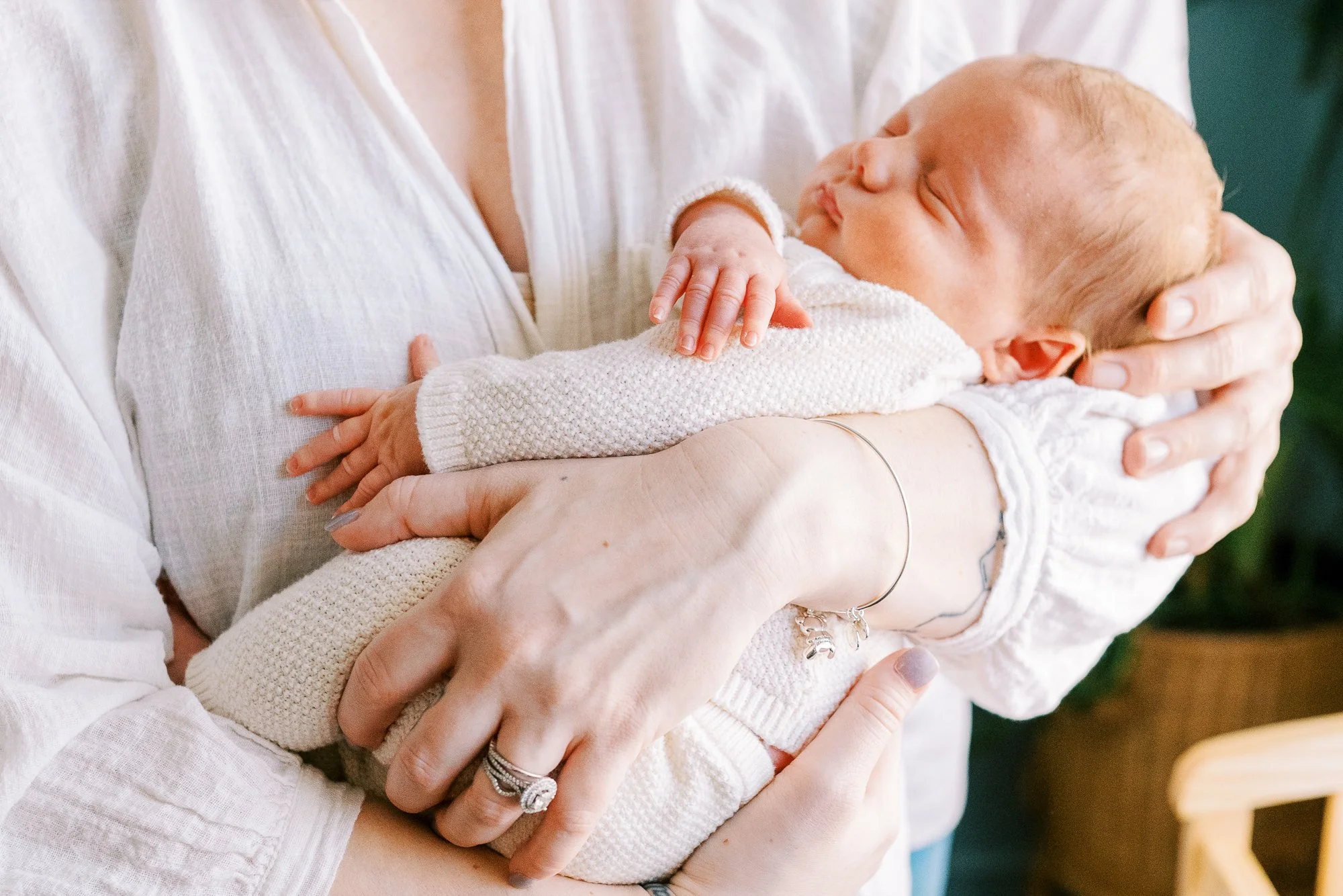 Dad embracing mom from behind as she holds their newborn baby, Roswell, Georgia