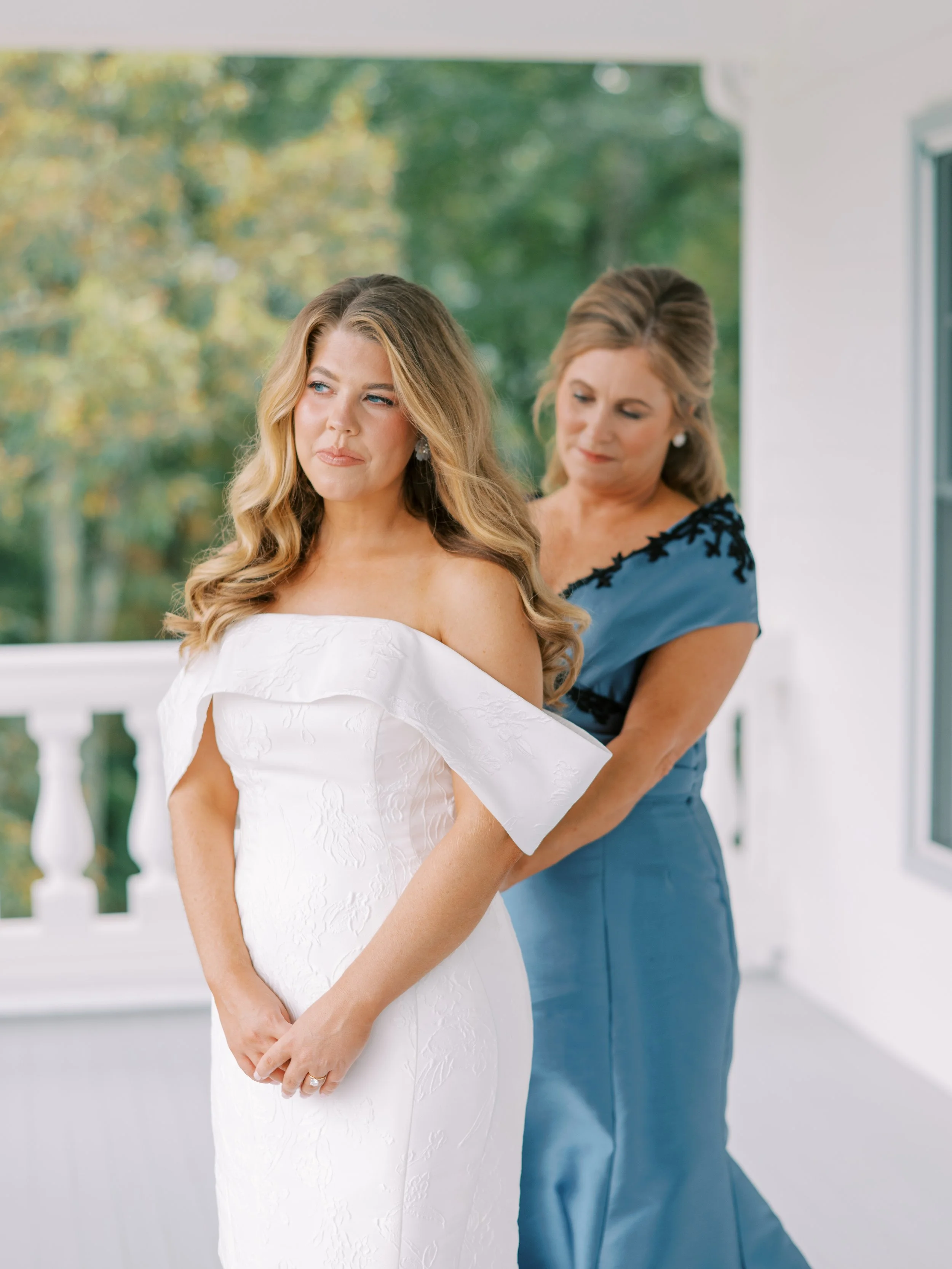 Bride and bridesmaid getting ready together on the porch