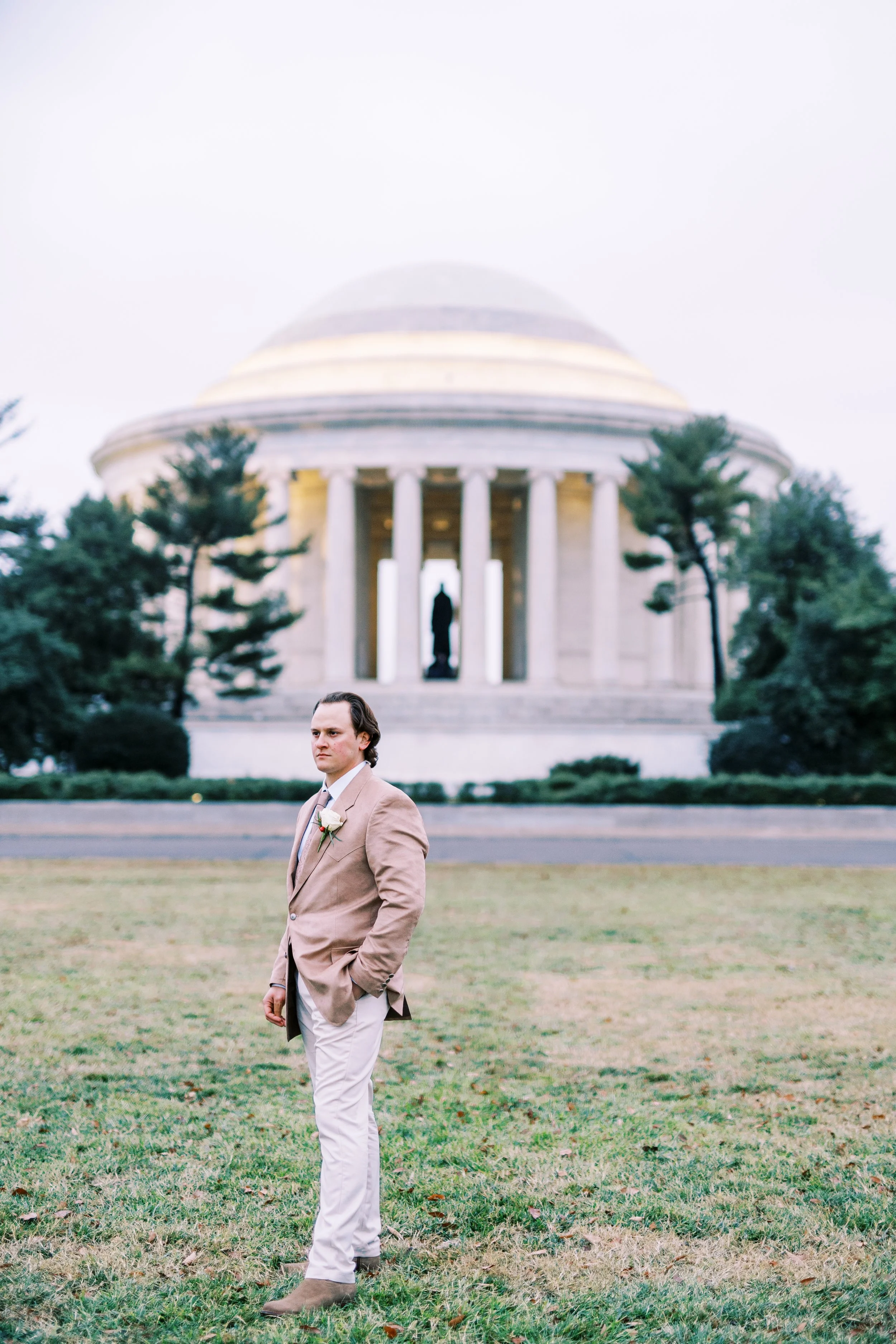 Groom standing solo on the lawn before the Jefferson Memorial