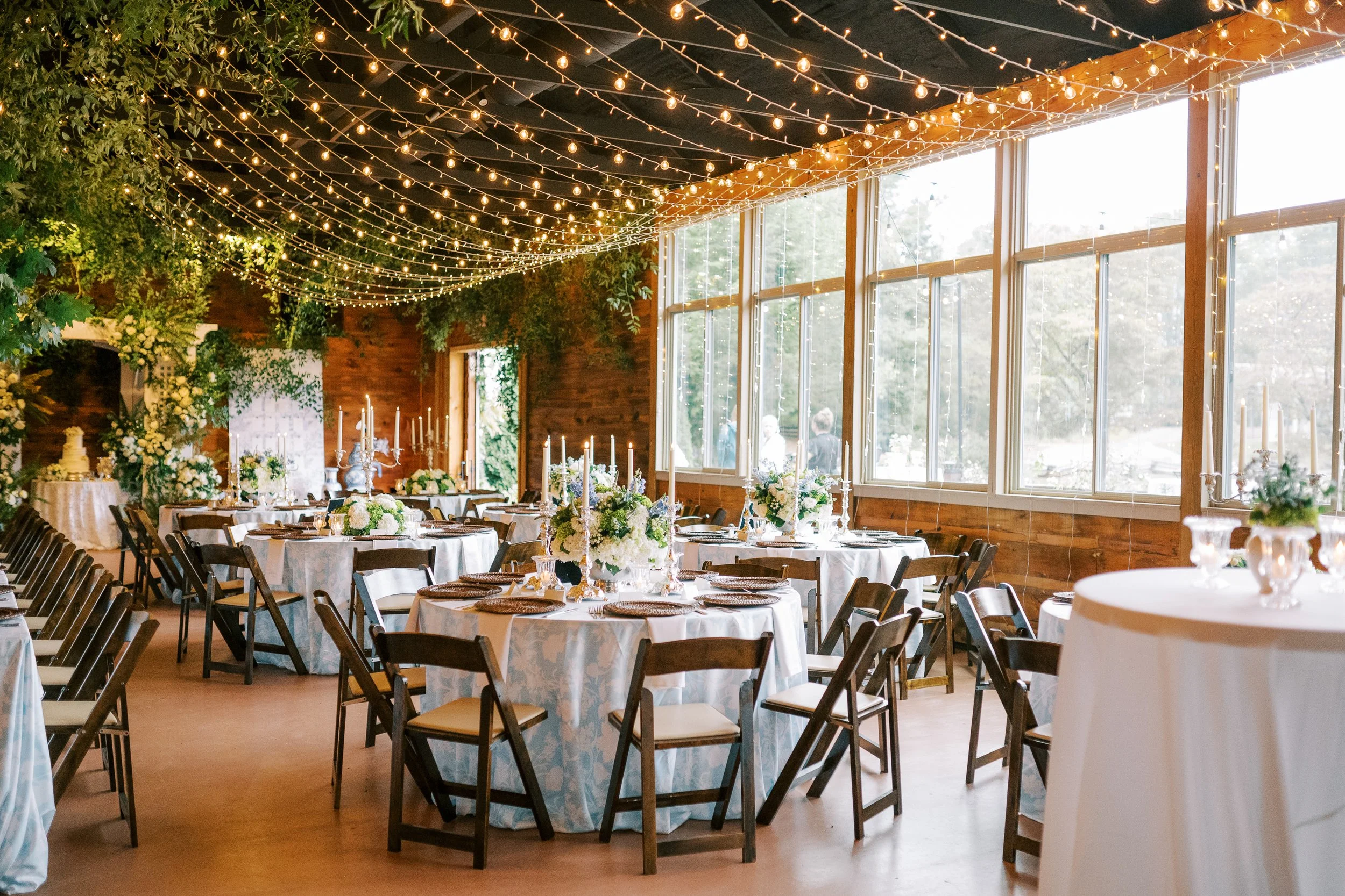 Reception hall interior with round guest tables and large windows