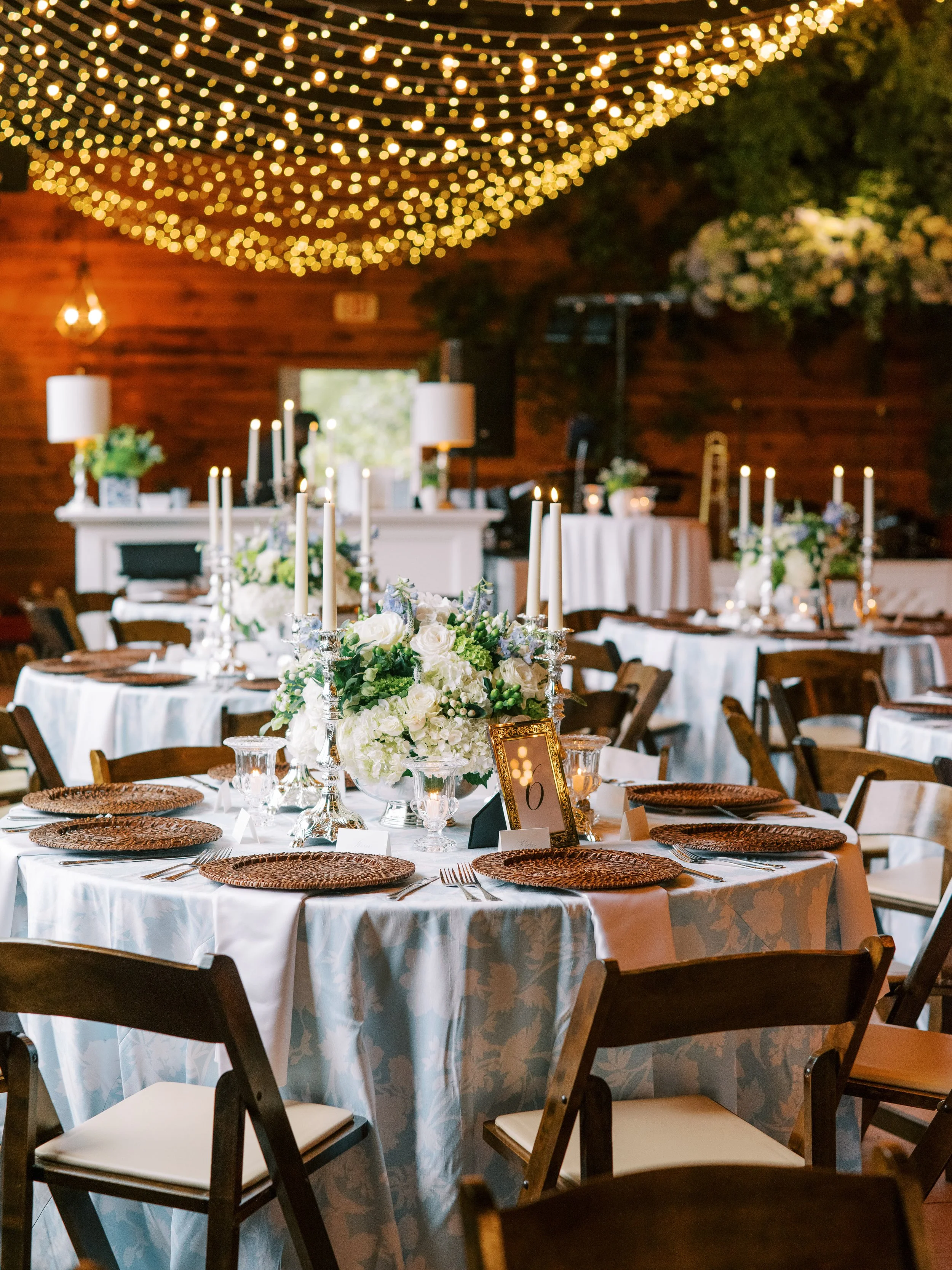 Reception table detail with floral centerpiece and candles at dusk