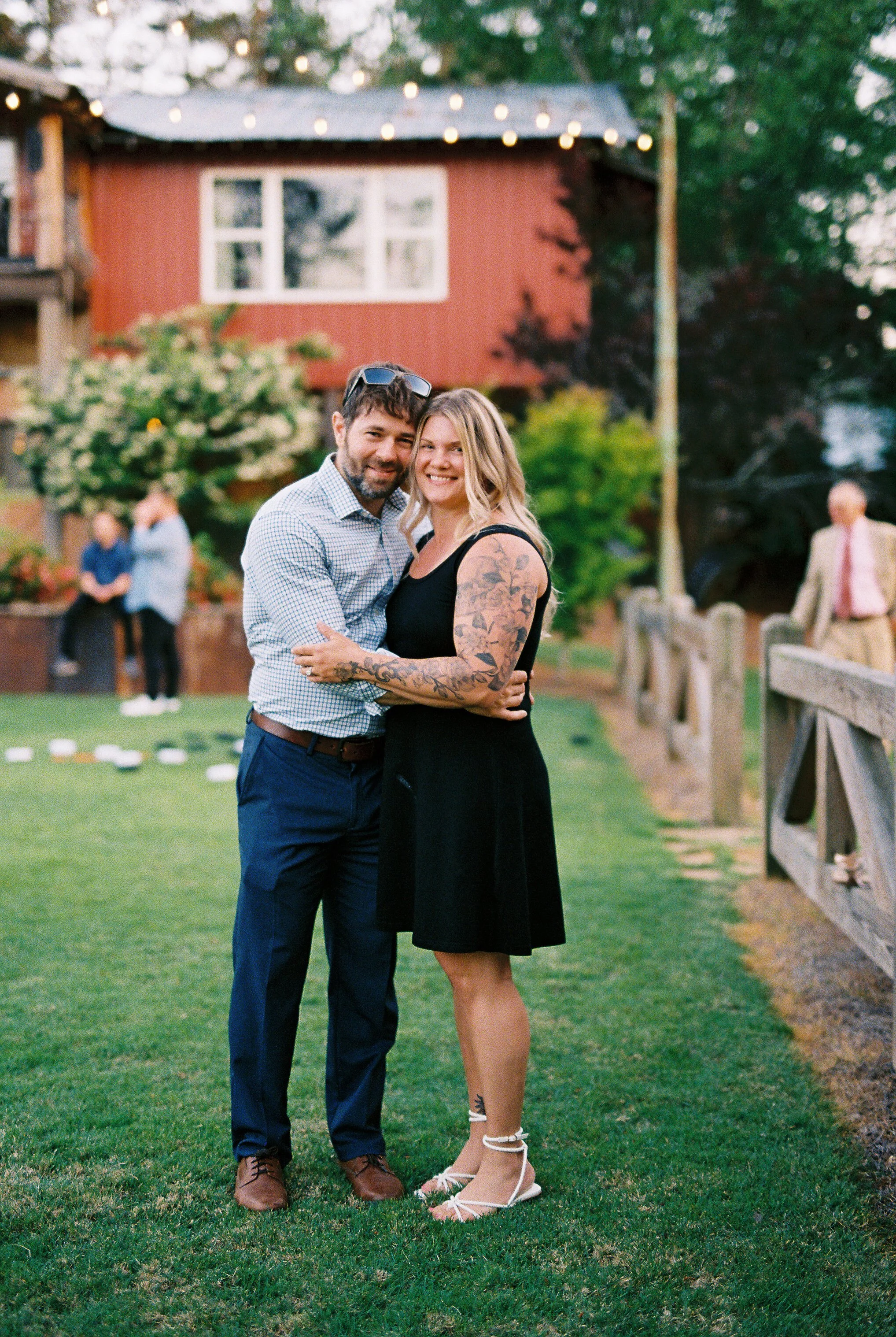Bride and groom holding Dakota the dog together at golden hour