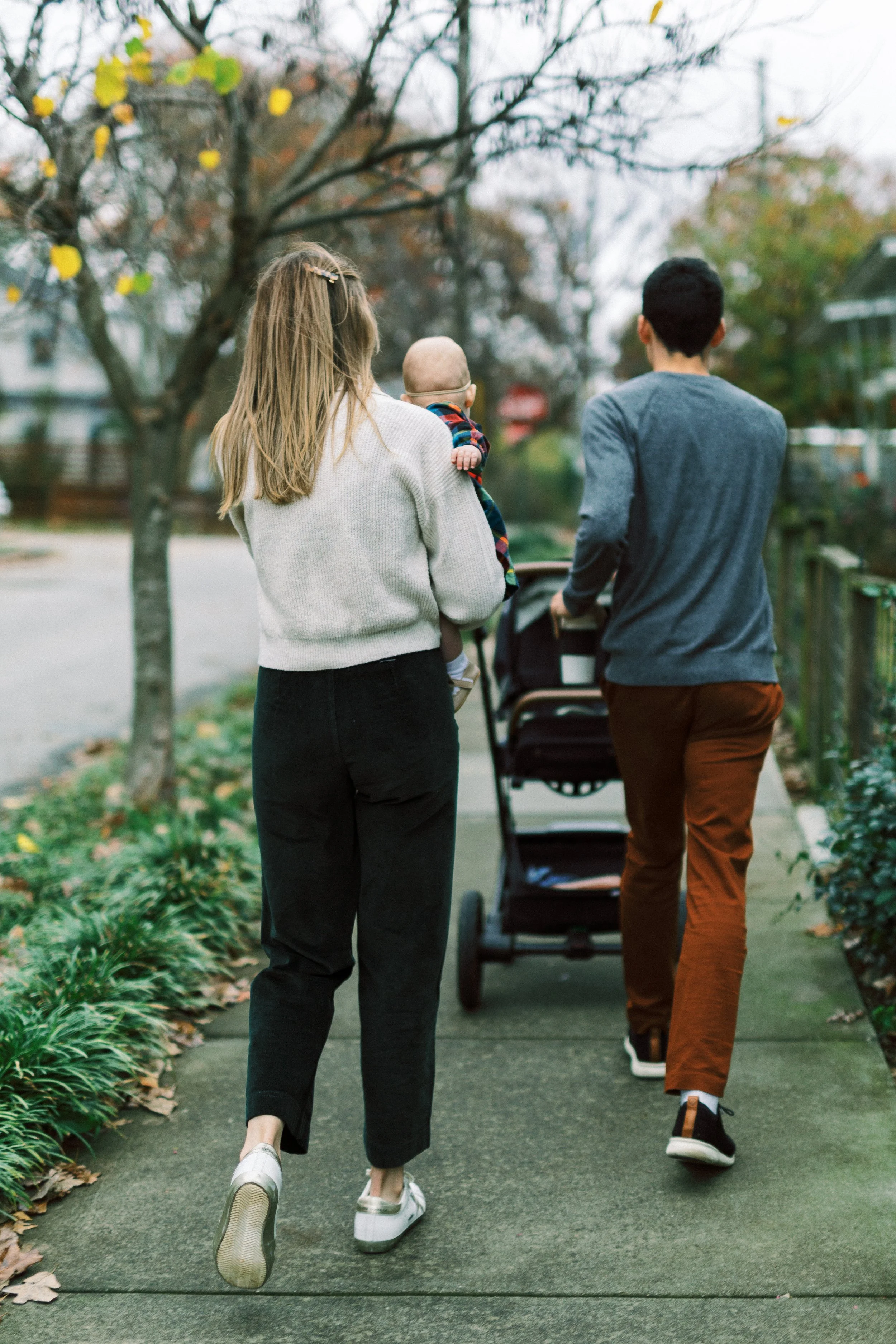 Family standing together smiling on a tree-lined sidewalk, Reynoldstown, Atlanta, Georgia
