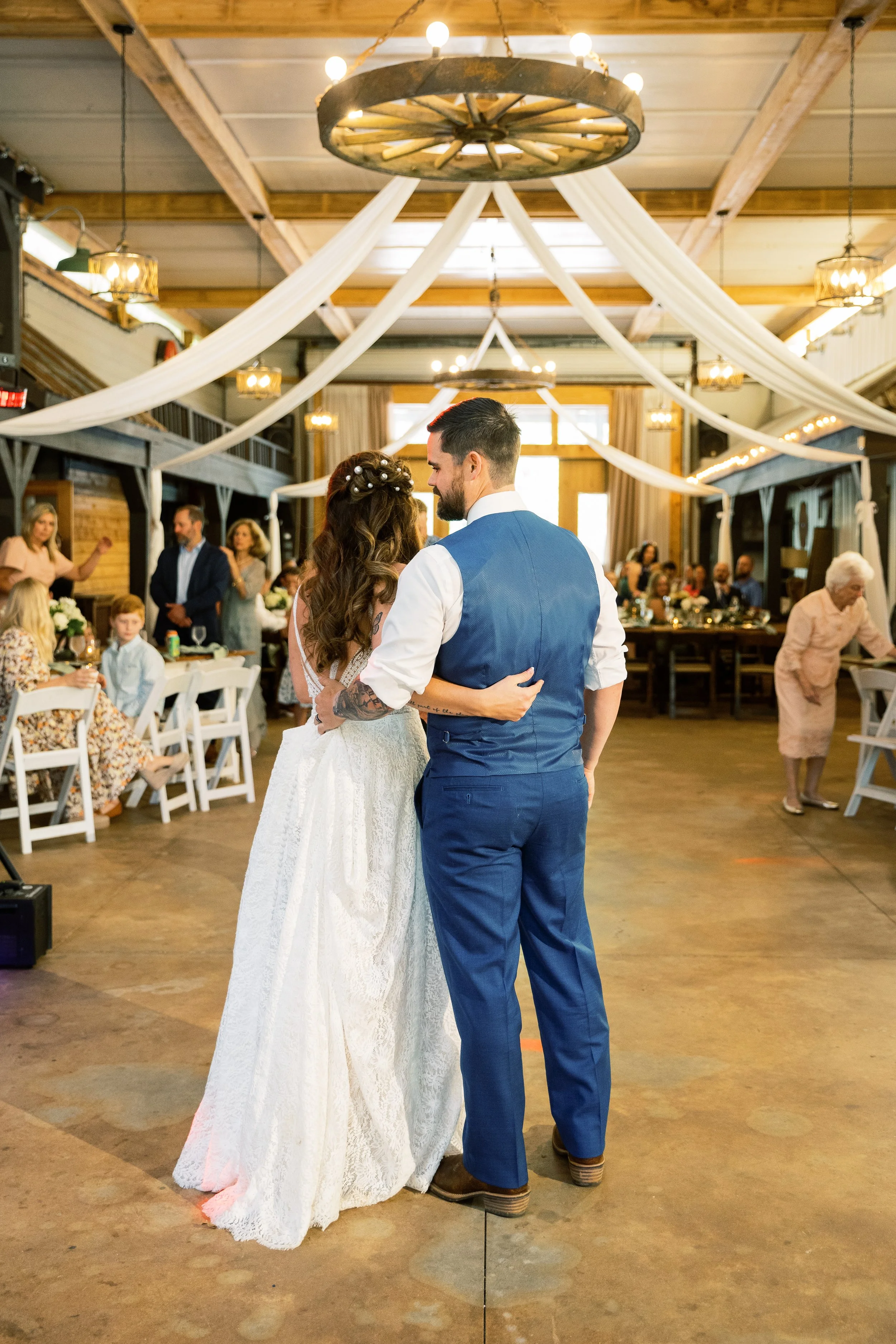 Bride and groom's first dance under a chandelier inside the reception venue