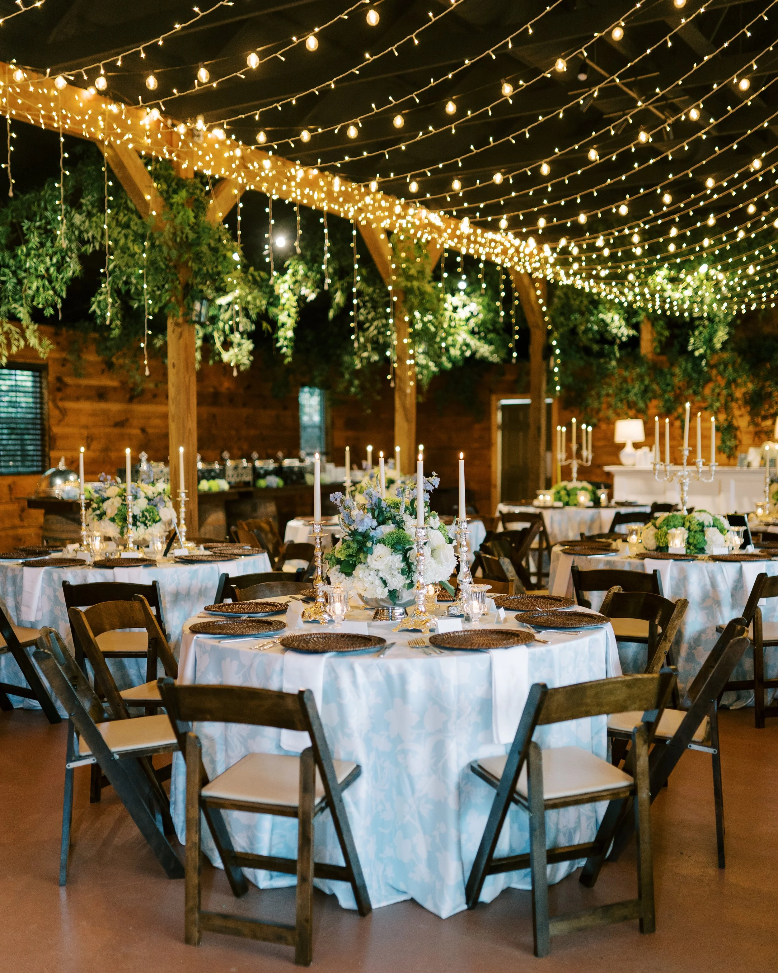 Reception dining area interior with string lights and table settings