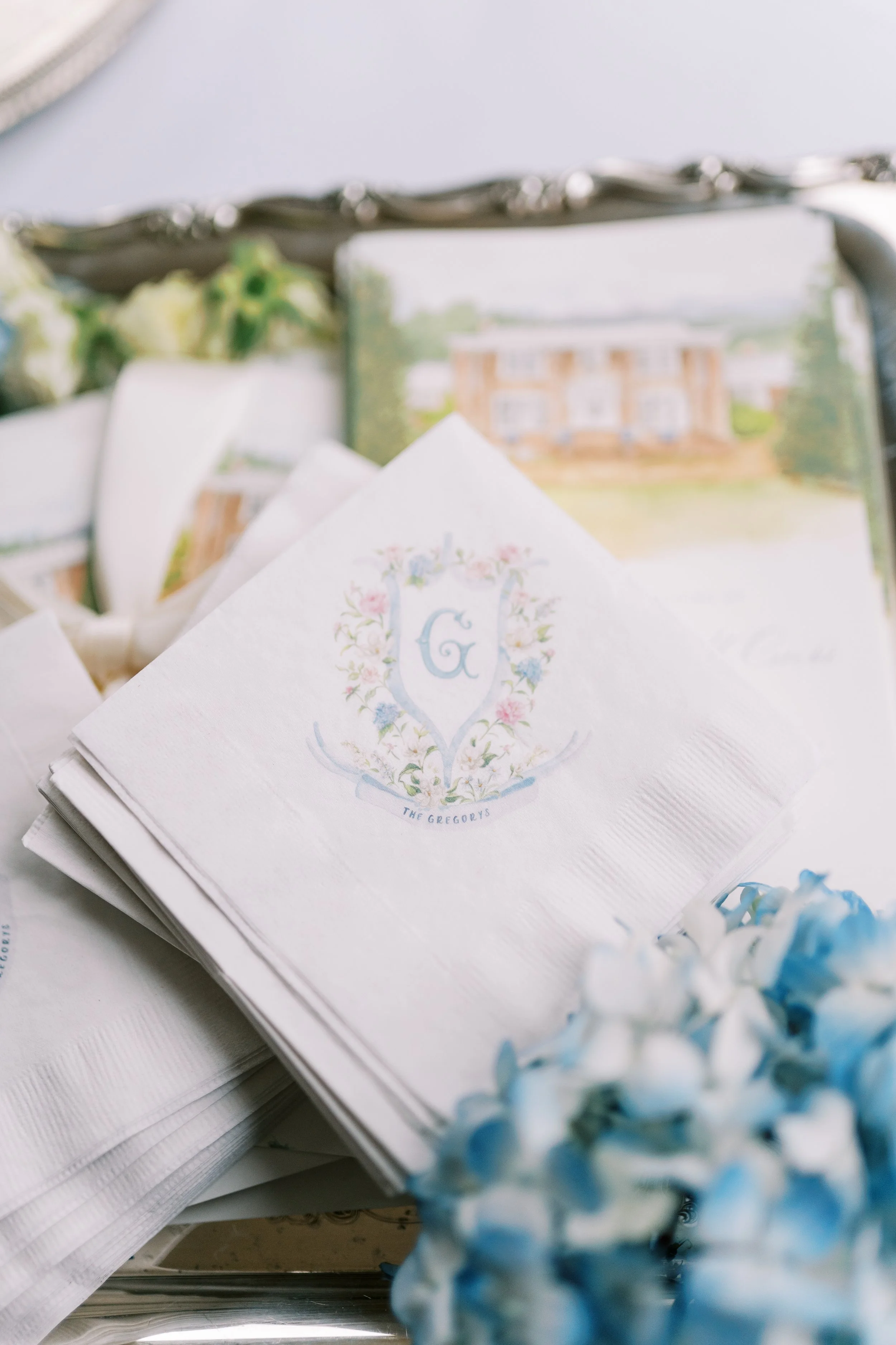 Flat lay of monogrammed linen napkins with blue floral details
