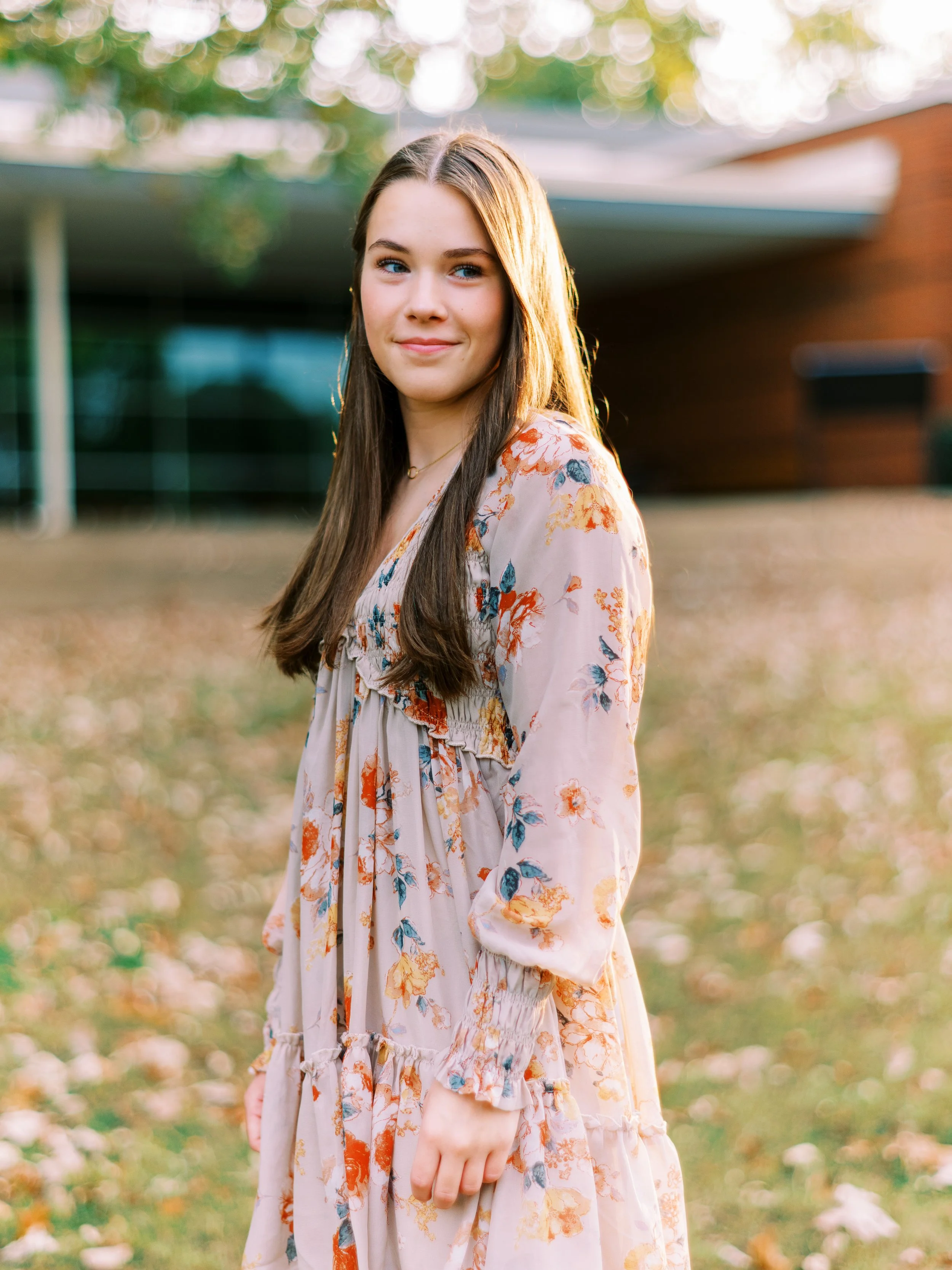 Senior portrait of Hannah standing on the lawn in a floral dress at Kennesaw Mountain Battlefield Park in Kennesaw, Georgia