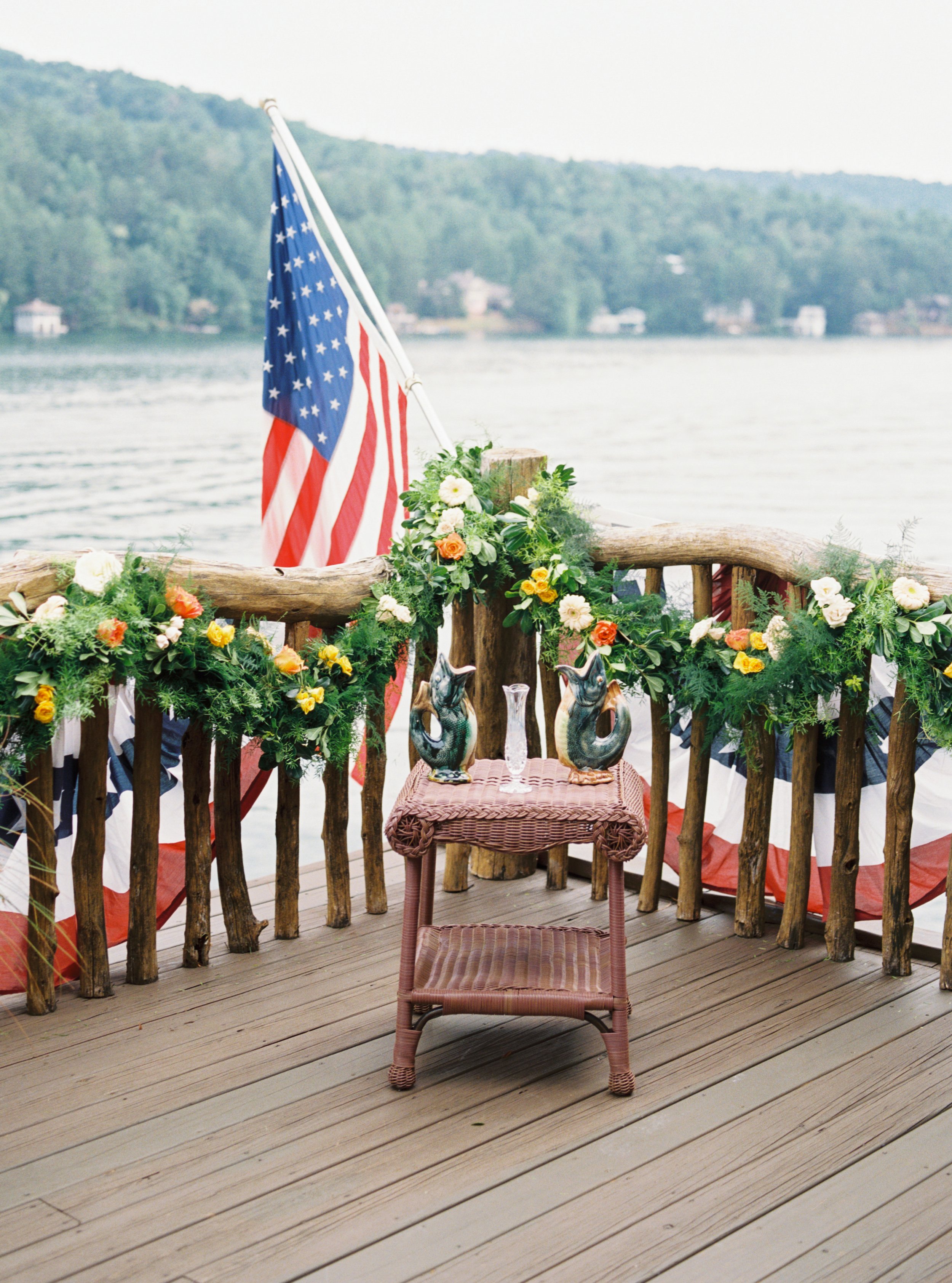 American flag and floral garland decorating a wooden deck railing overlooking Lake Rabun, Georgia