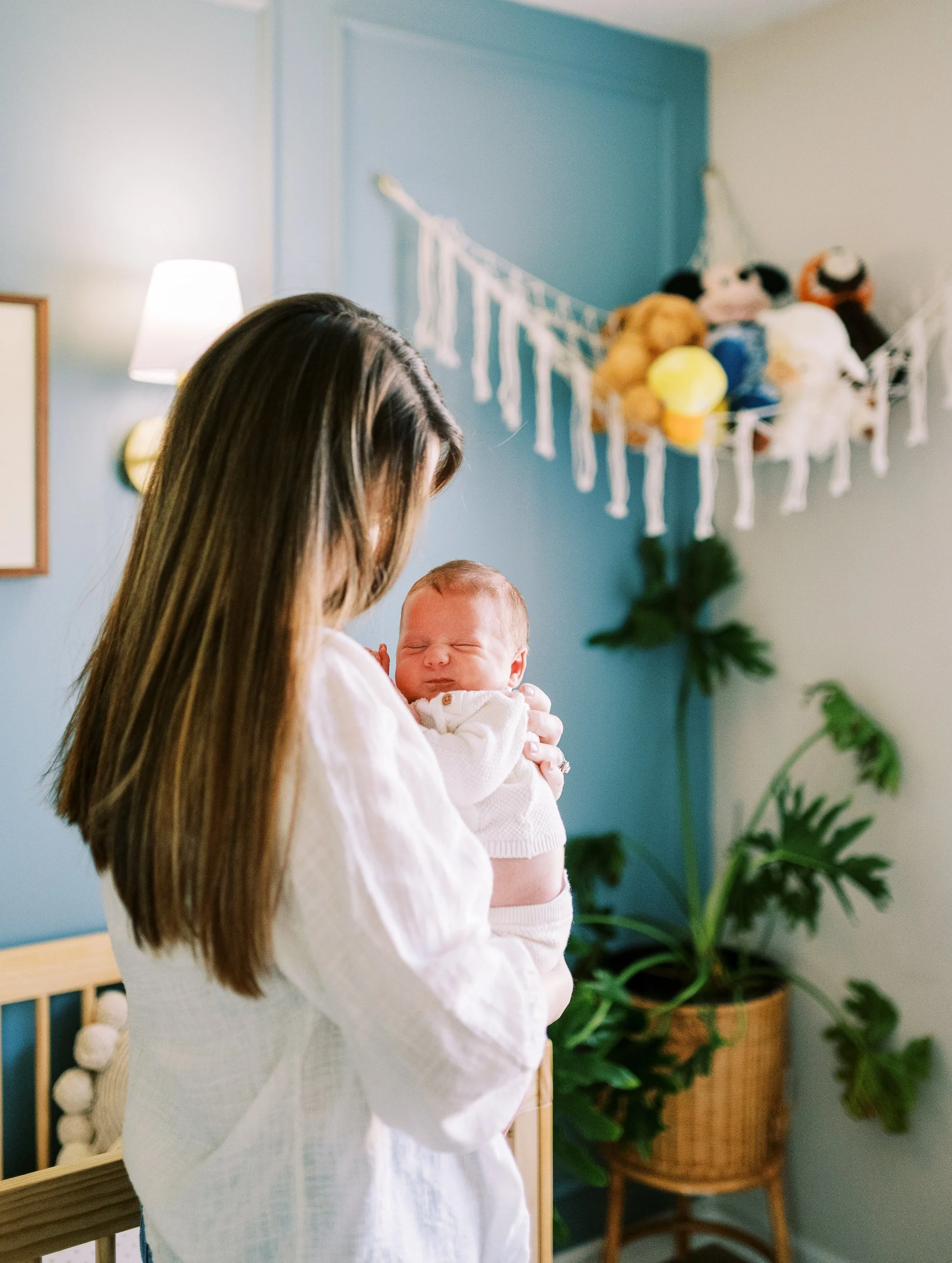 Mother gazing down tenderly at her newborn baby cradled in her arms, Roswell, Georgia