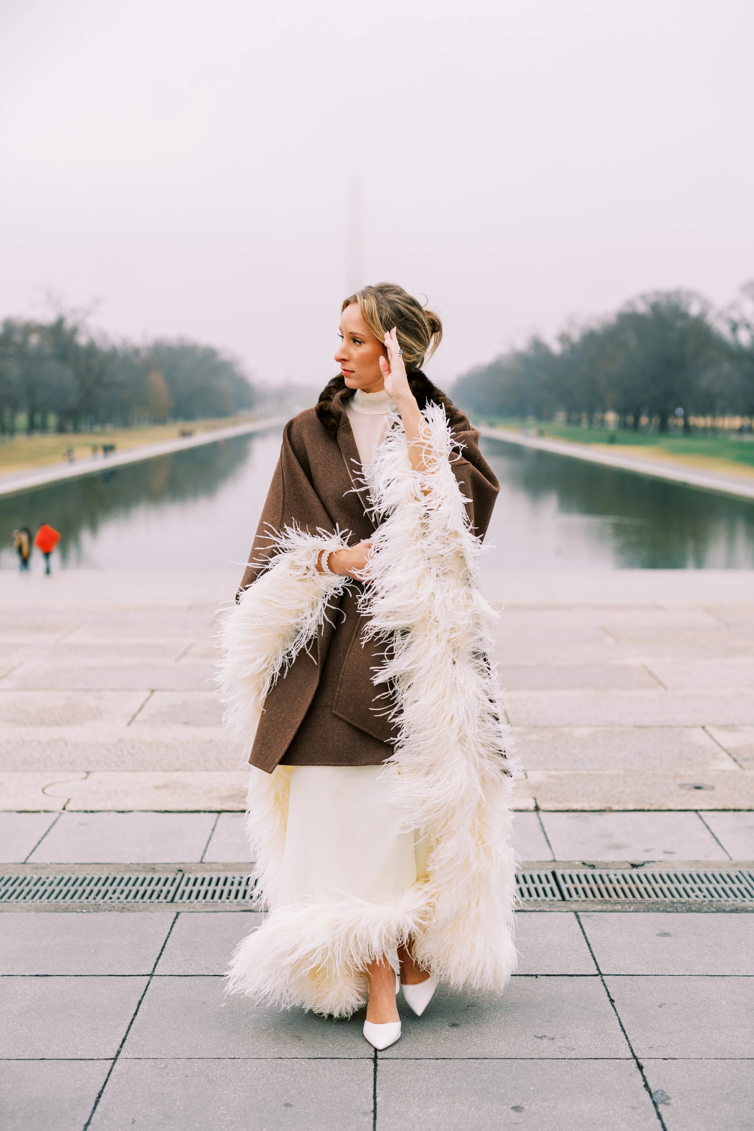 Bride standing solo on the walkway beside the reflecting pool