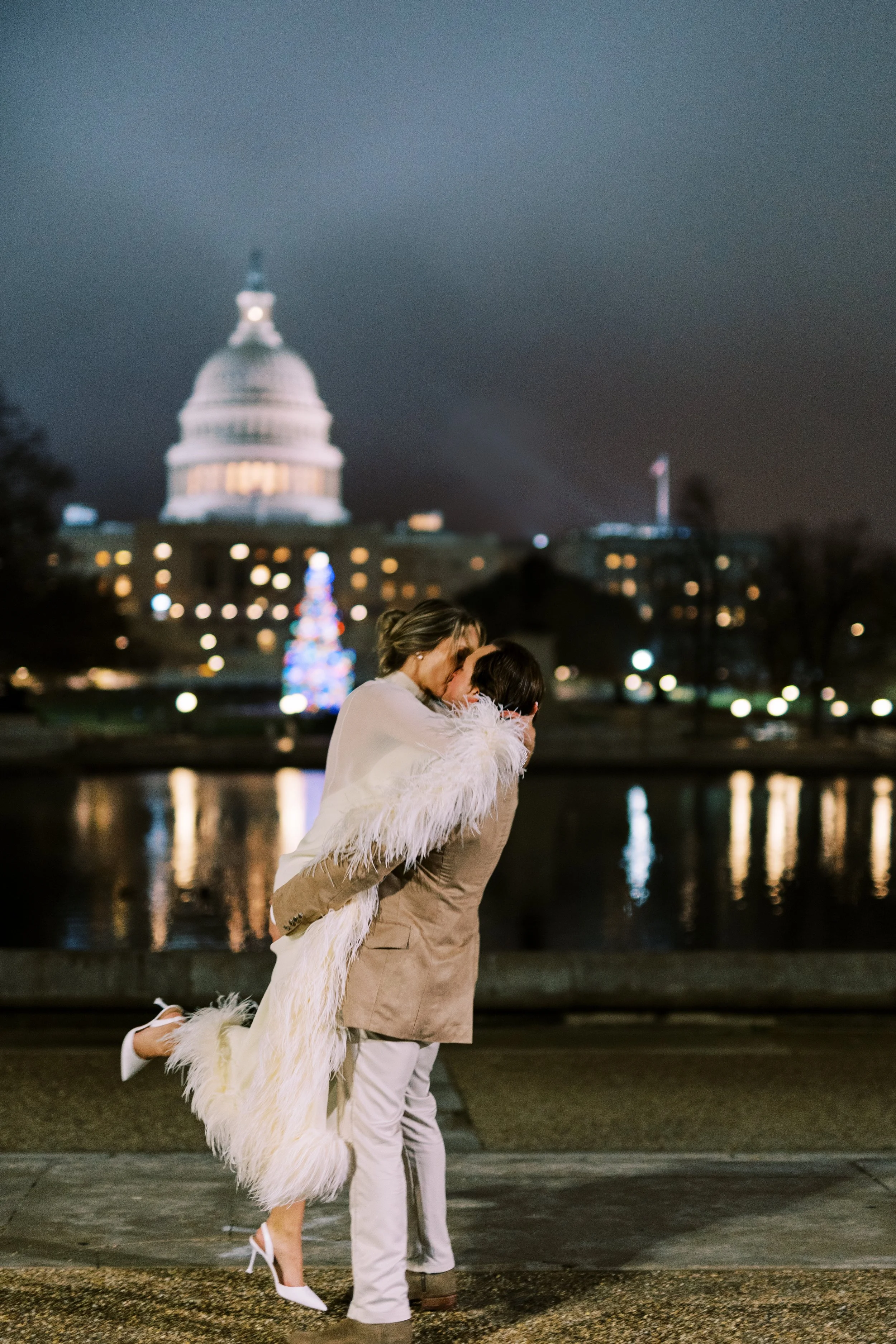 Bride and groom kissing at night with the illuminated Capitol dome behind them