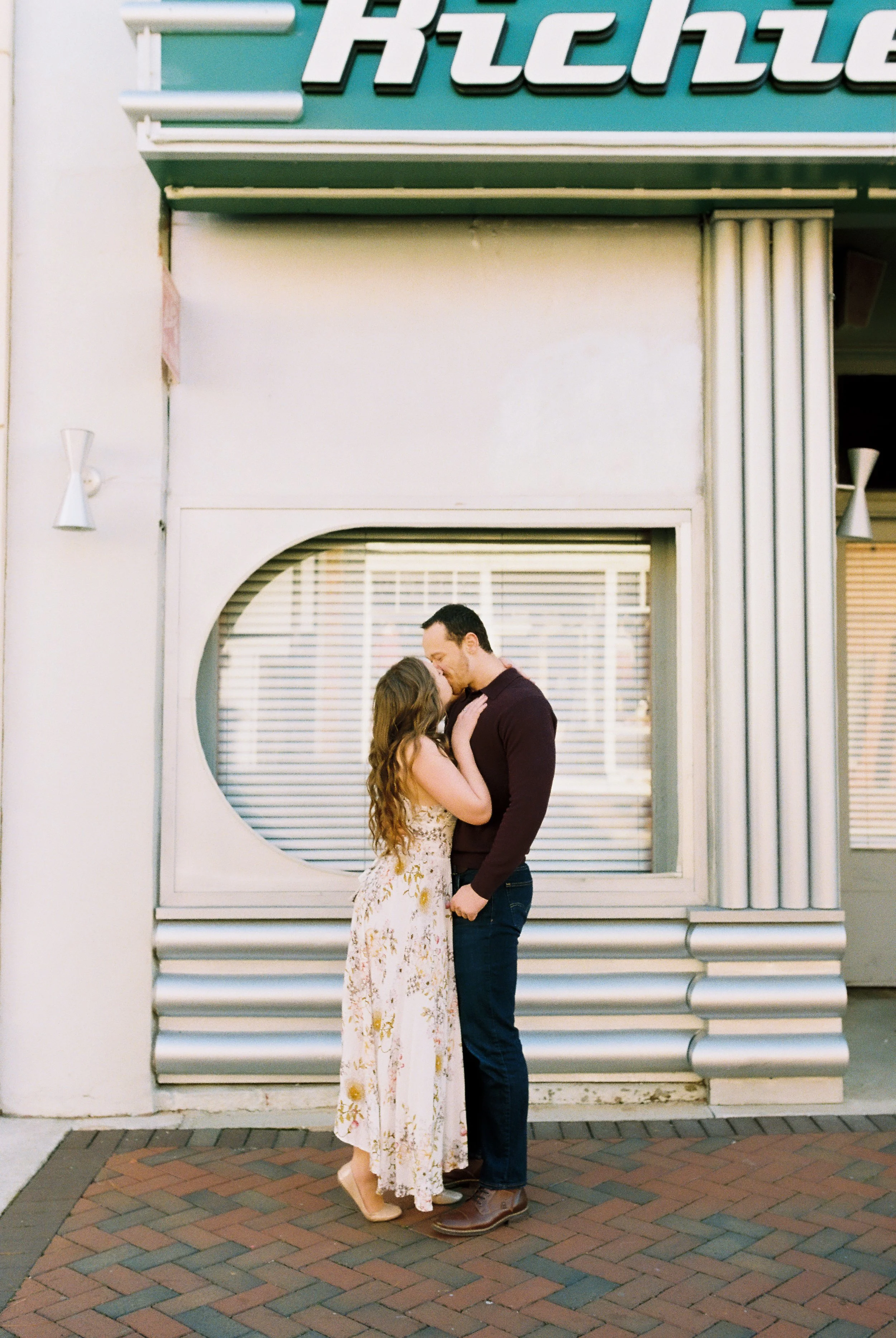 Conner and Maddie share a kiss in front of an art deco storefront in downtown Dallas, Georgia.