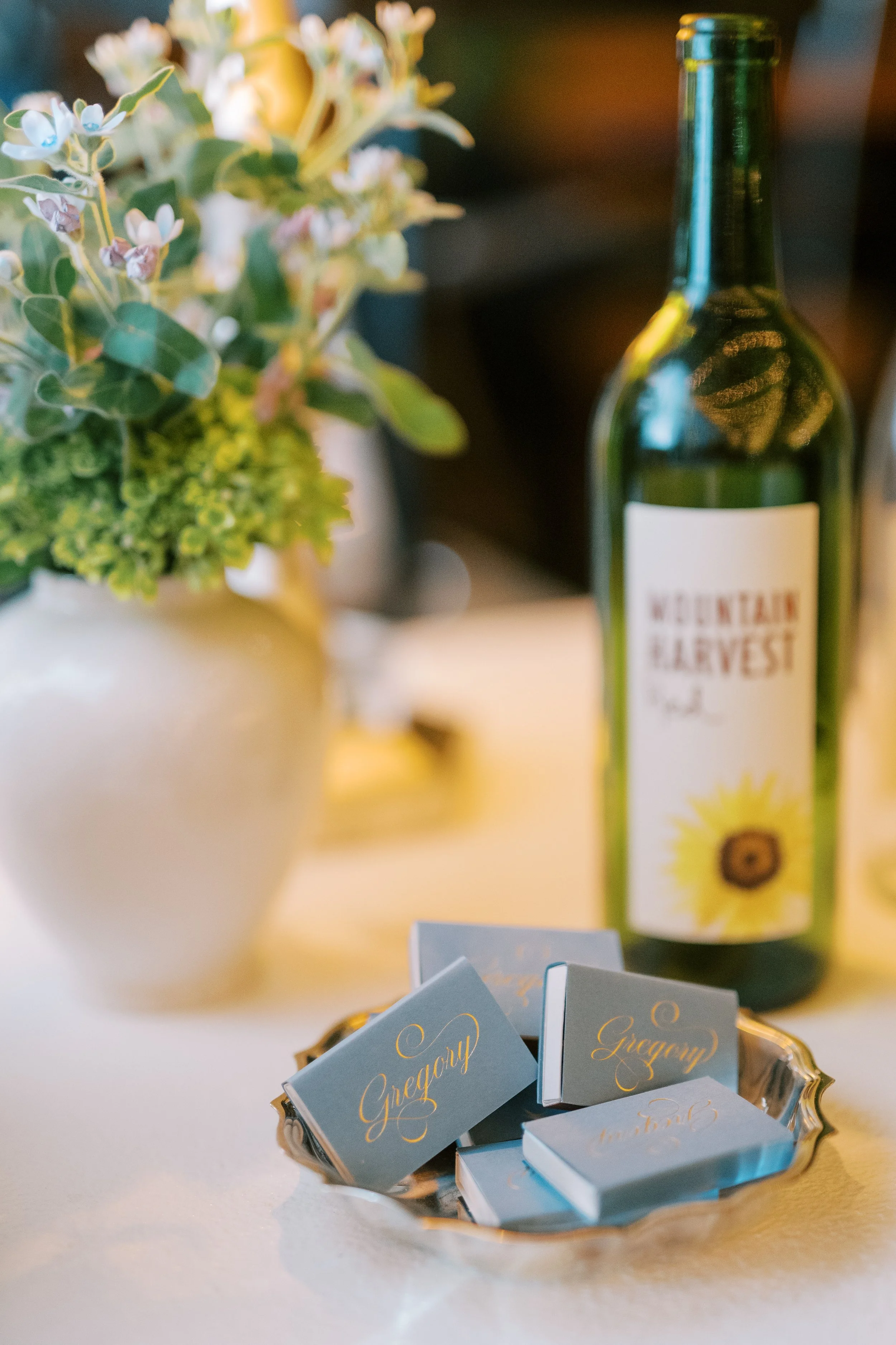 Flat lay of wine bottle with florals and favor details