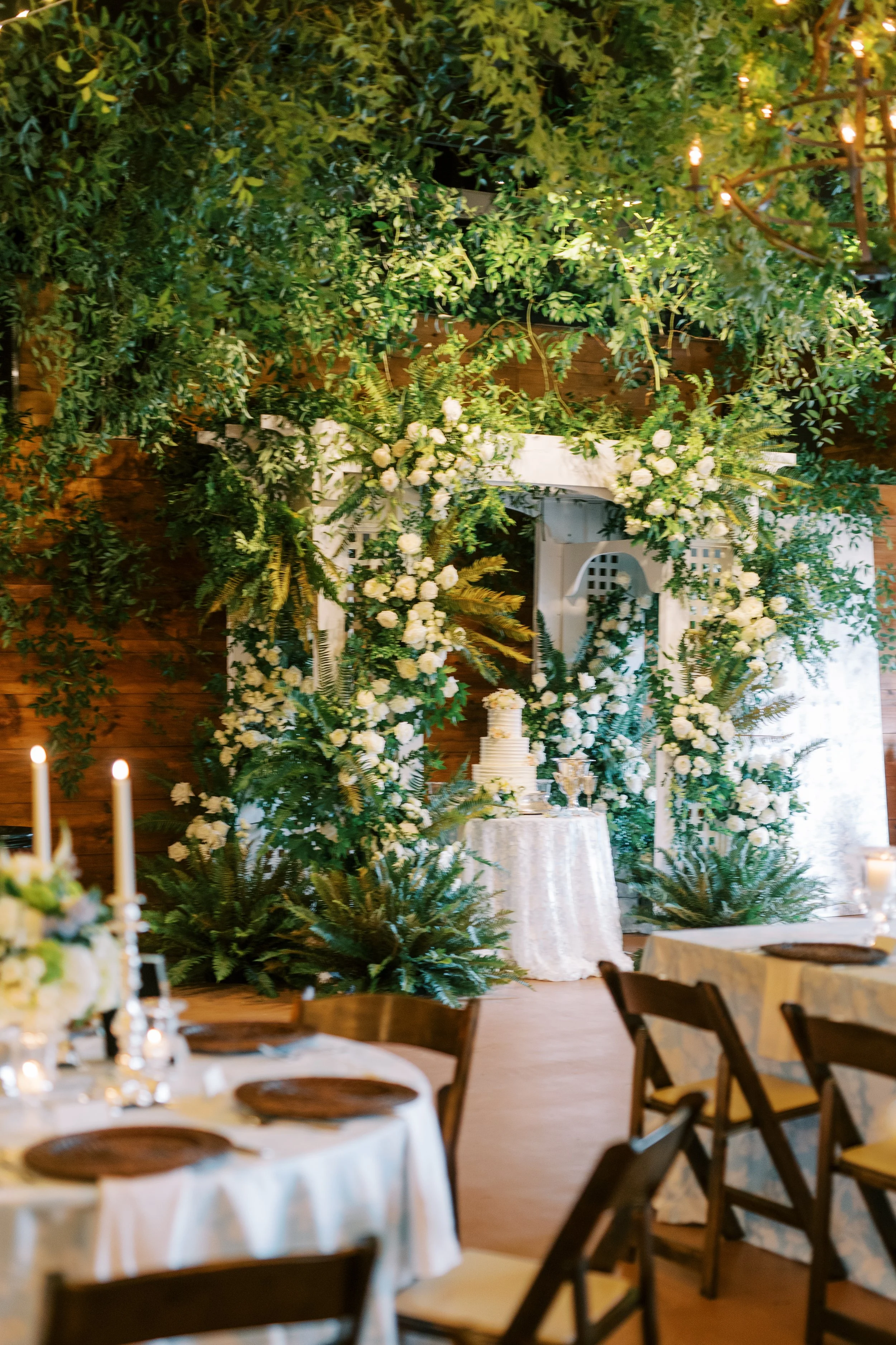 Ceremony arch decorated with greenery and florals at the reception venue