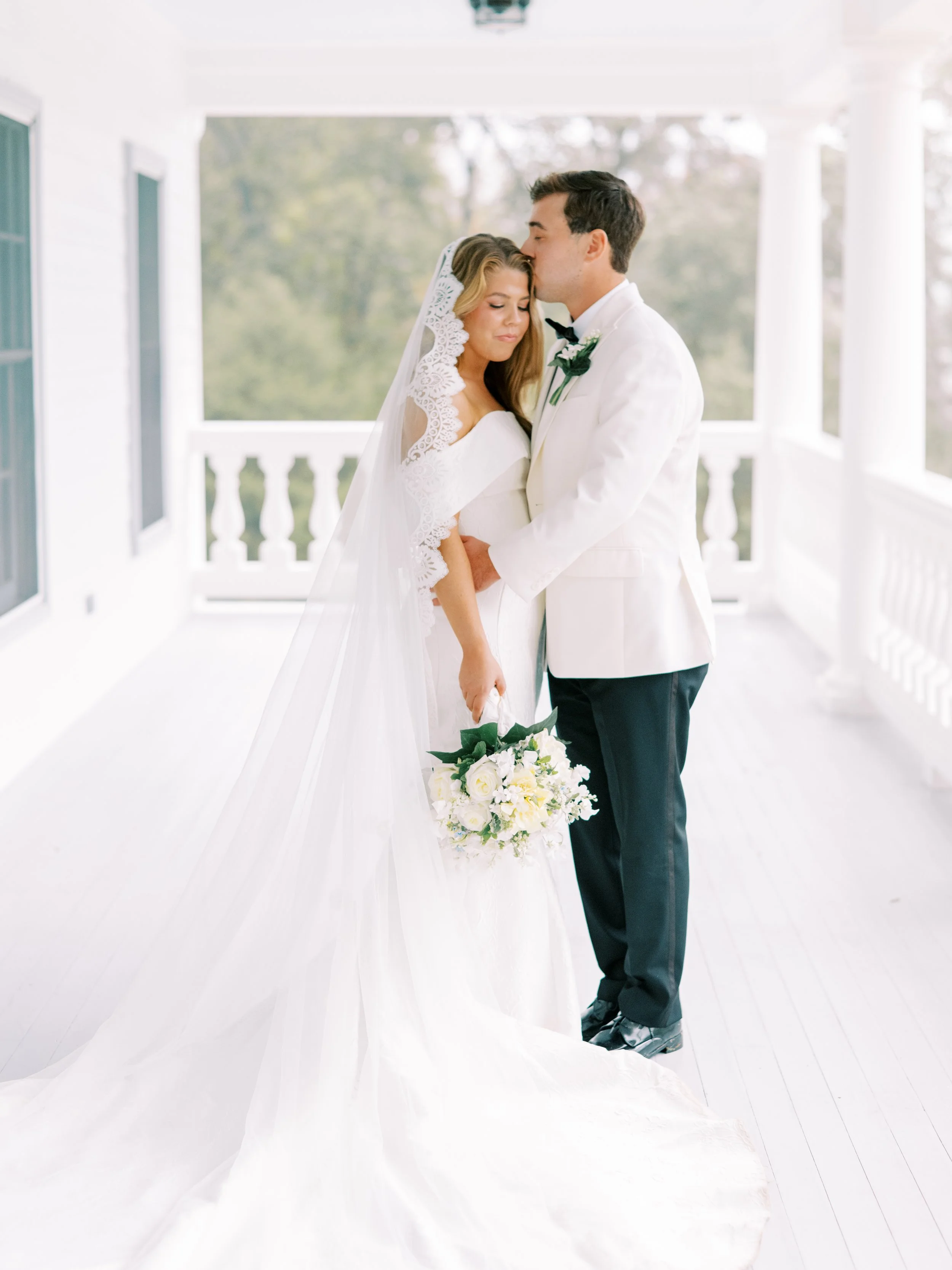 Bride and groom embracing in the plantation house breezeway