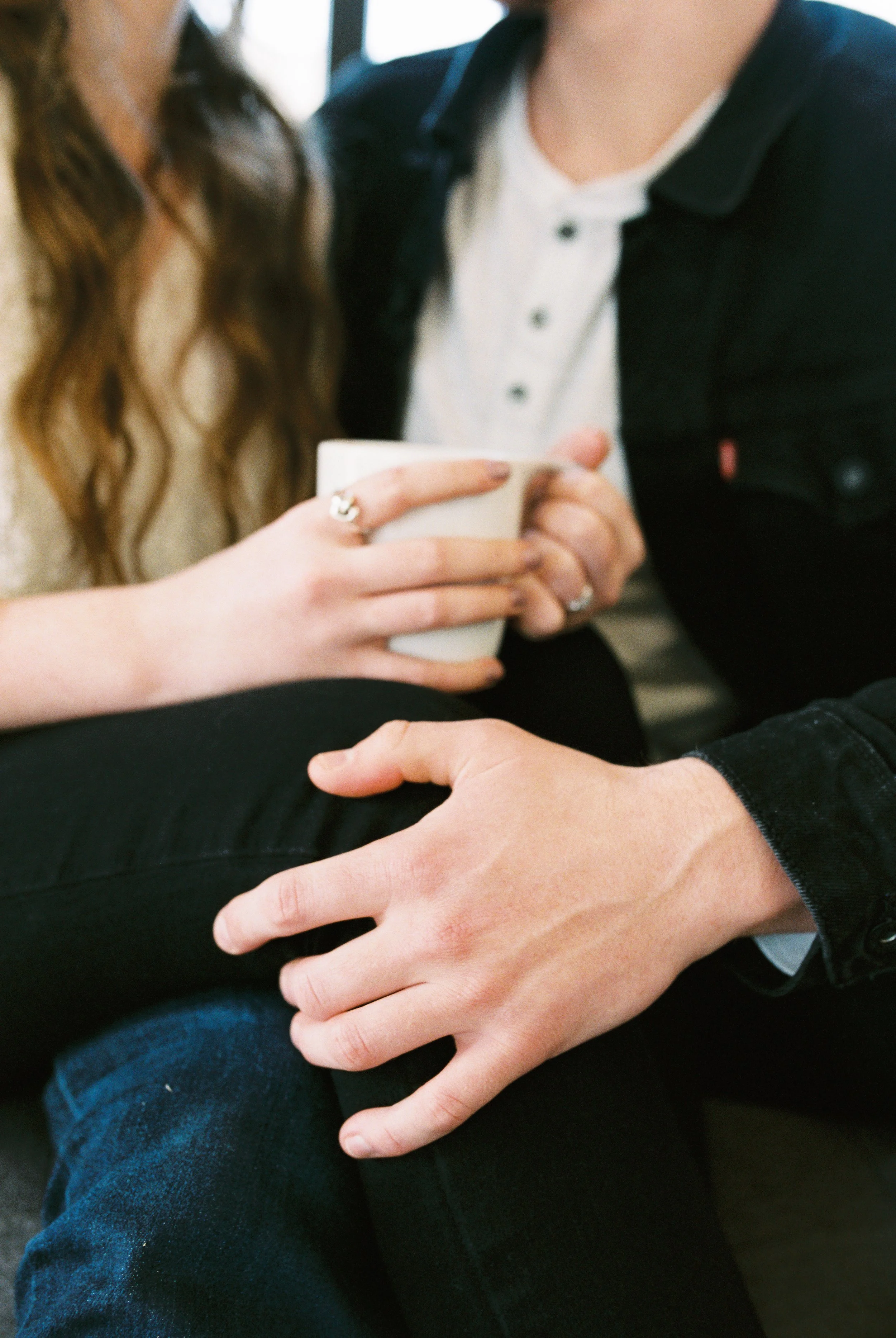 A detail shot of Conner and Maddie's hands and coffee mug while seated together in a Dallas, Georgia coffee shop.