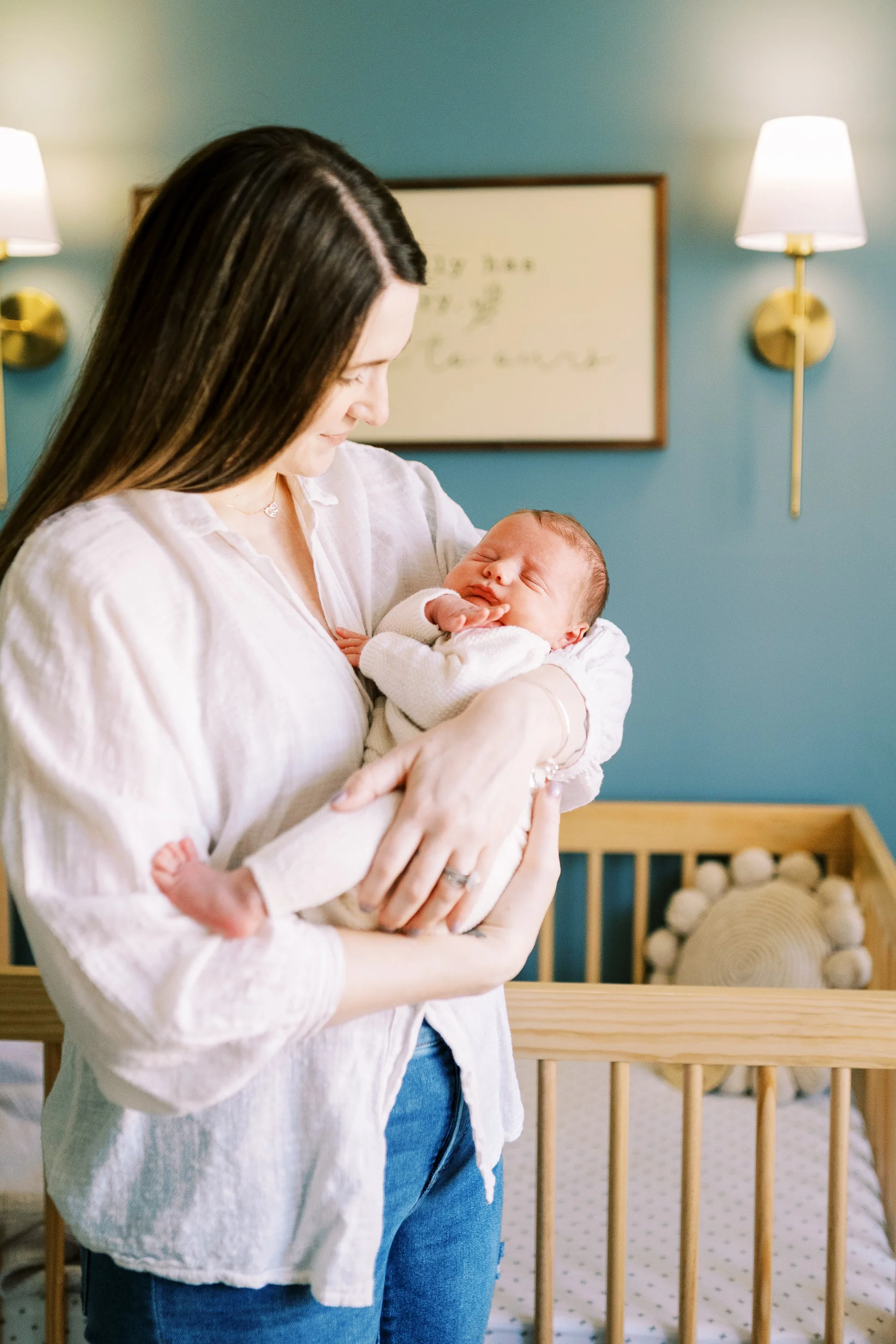 Mother nuzzling her newborn nose to nose while baby's tiny fist rests near his mouth, Roswell, Georgia