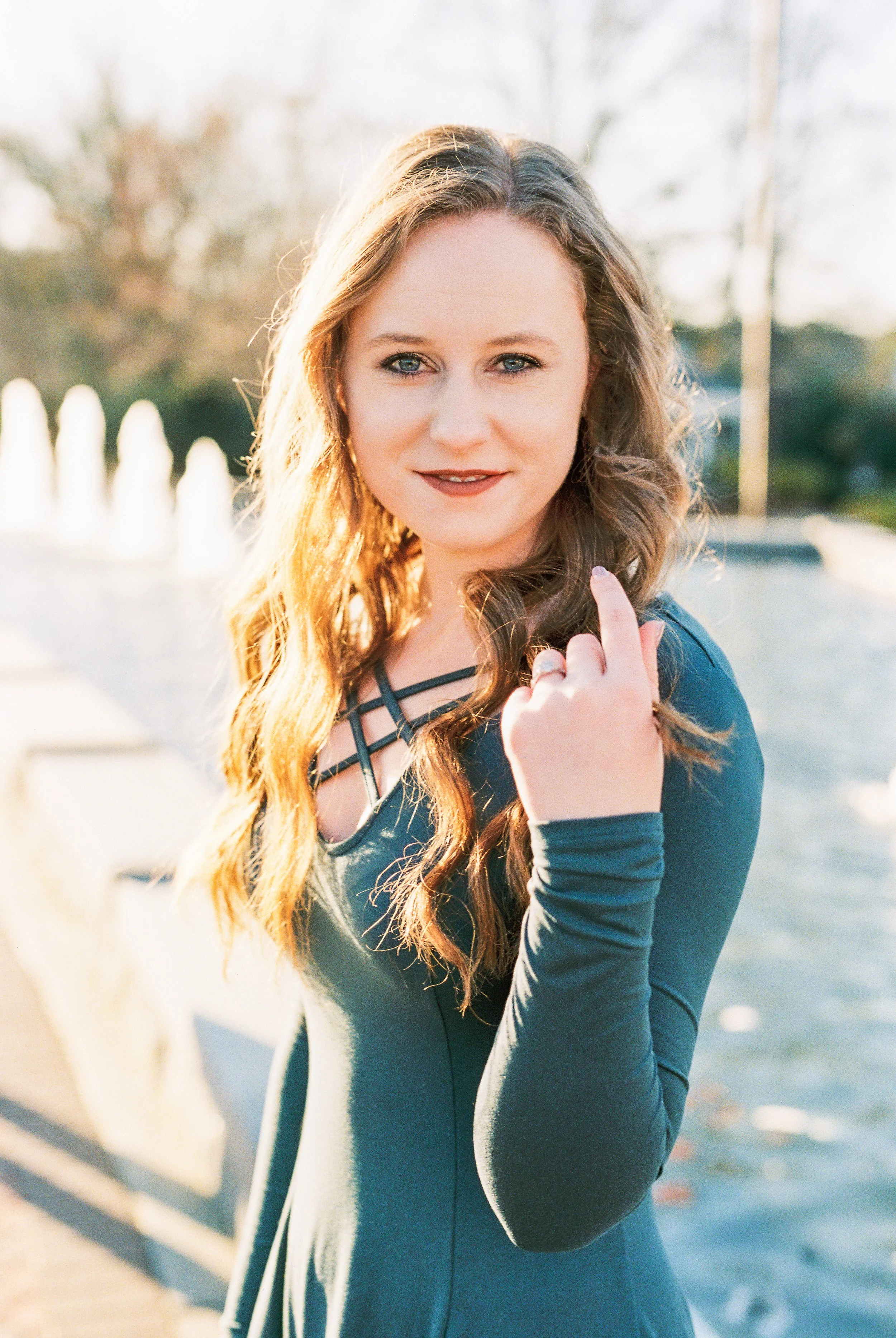 Maddie poses for a solo portrait beside a fountain at golden hour in Dallas, Georgia.
