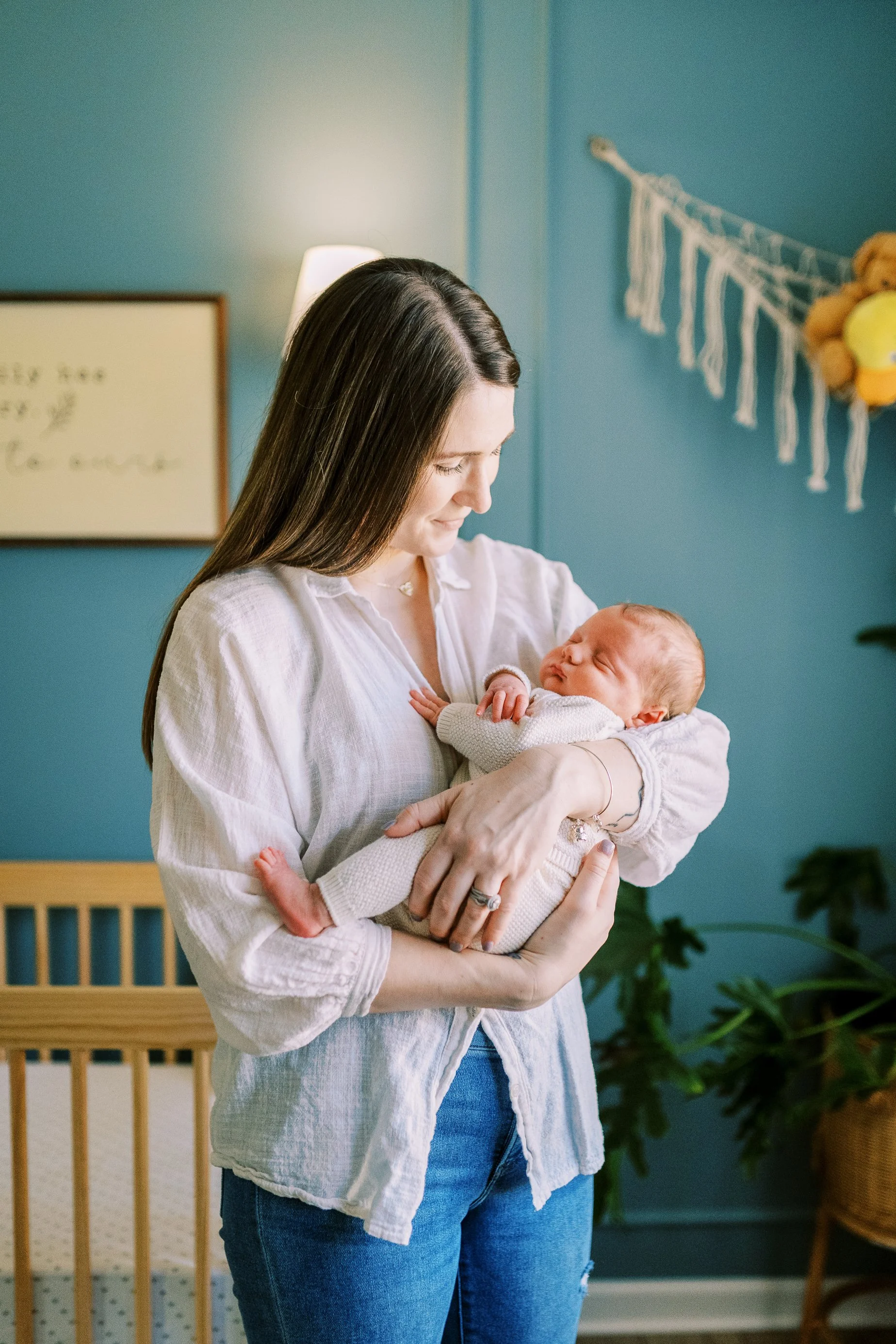 Mother gazing thoughtfully to the side while cradling her newborn baby, Roswell, Georgia