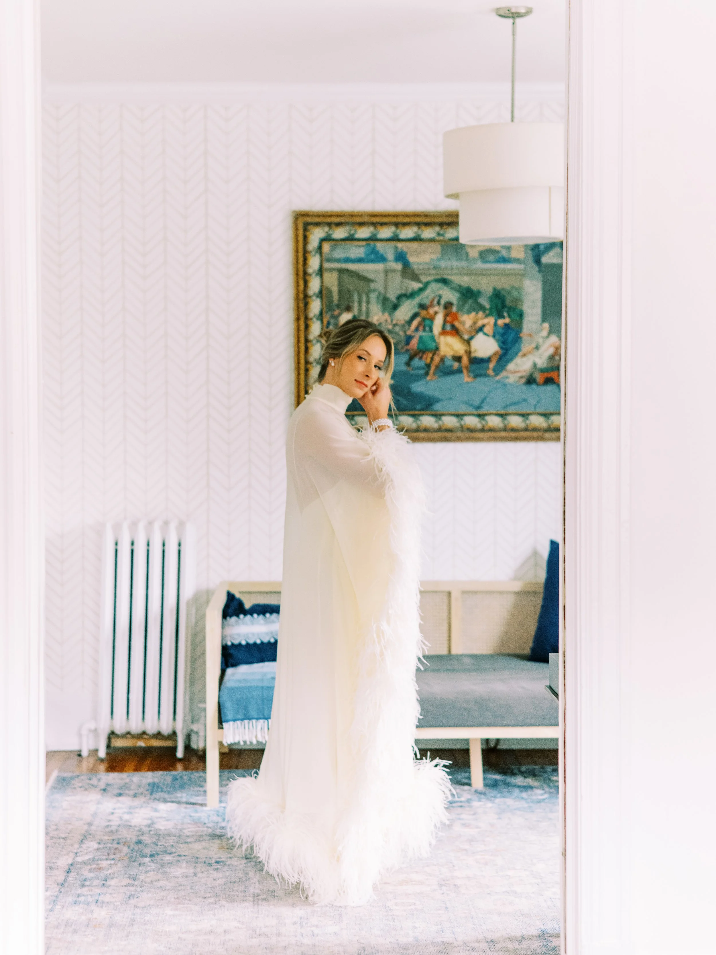 Bride standing solo in an elegant sitting room before the ceremony