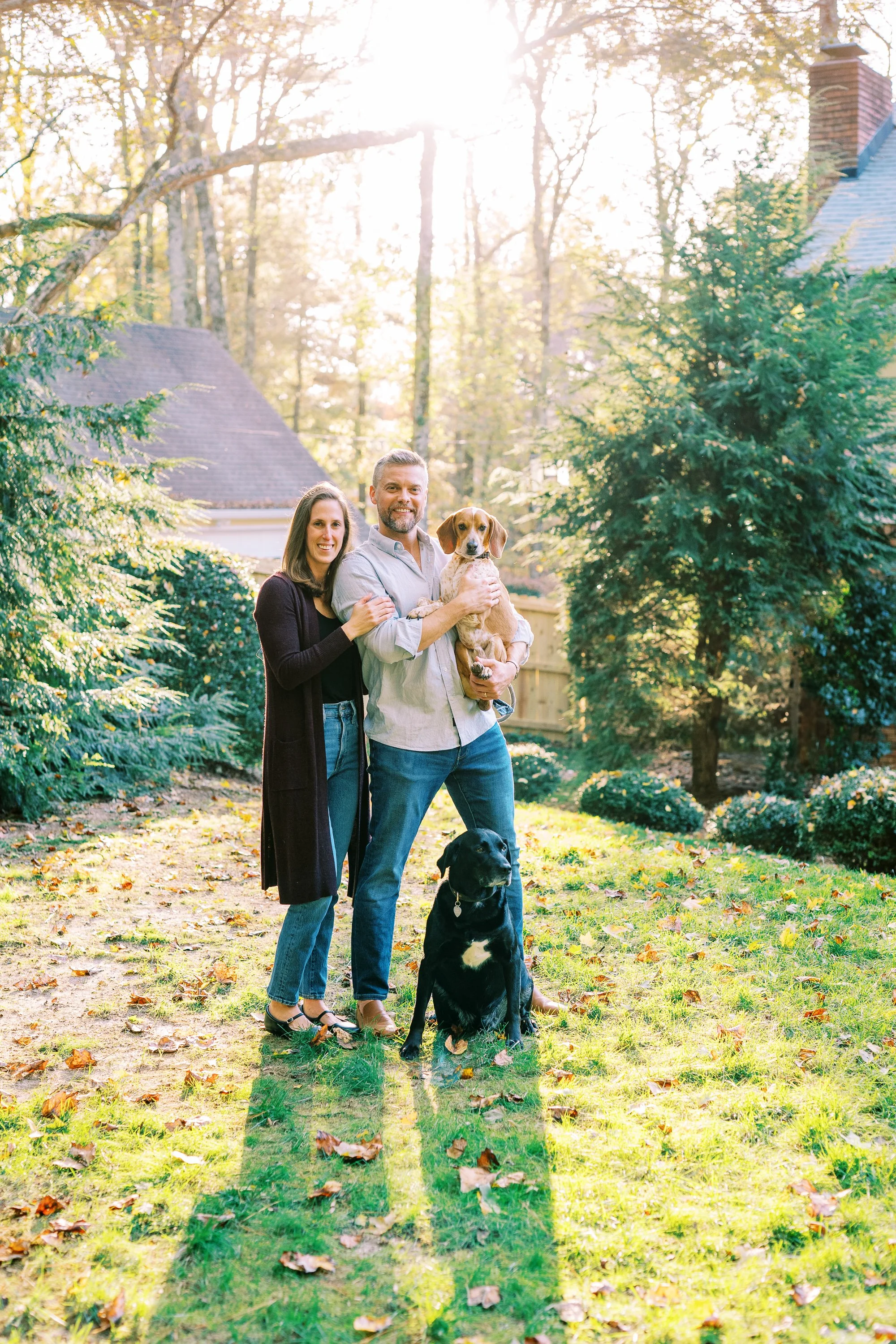 Holly, Chris, their child, and dog walking together in the wooded yard in Dunwoody, Georgia