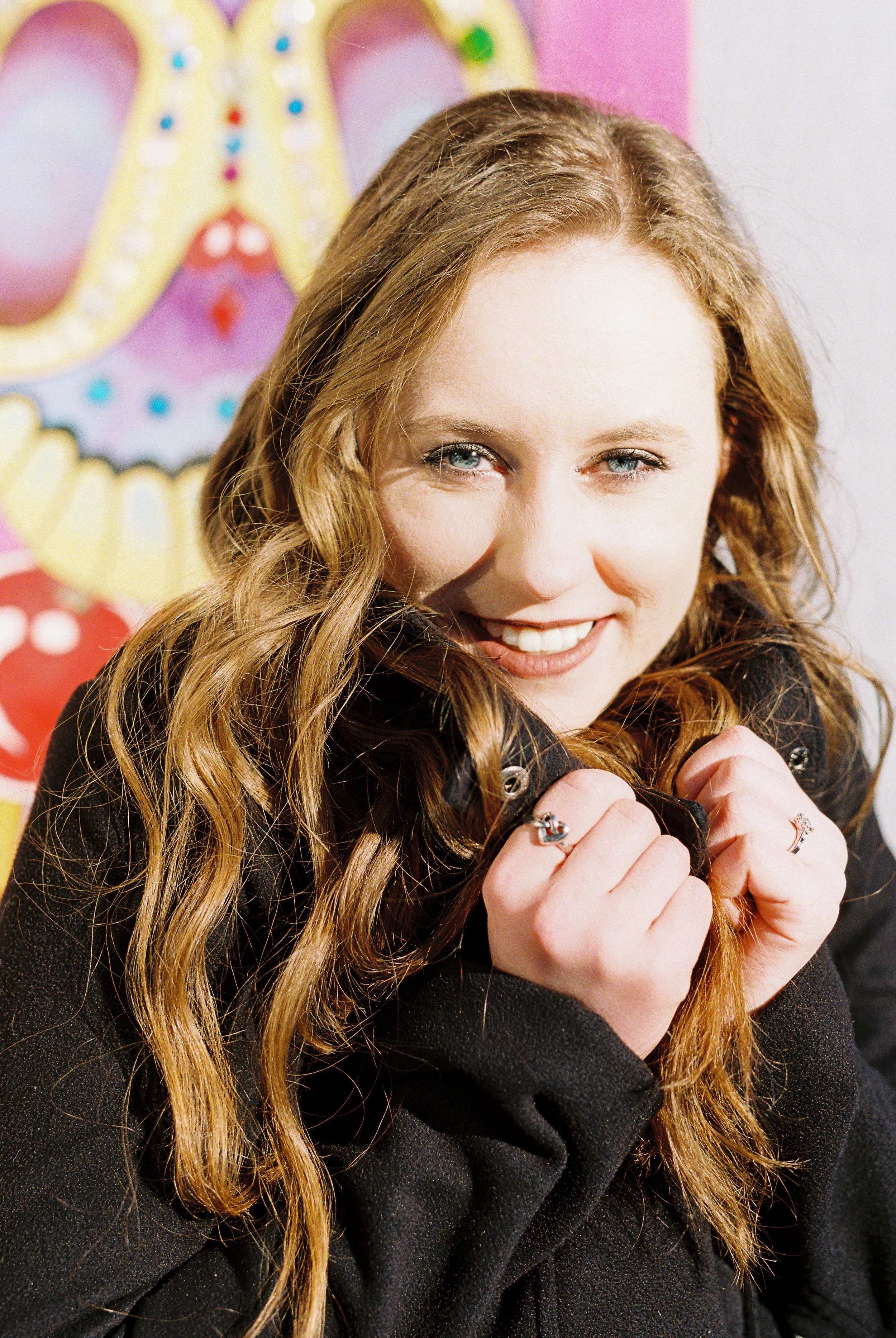 Maddie smiles for a solo portrait against a colorful mural backdrop in downtown Dallas, Georgia.